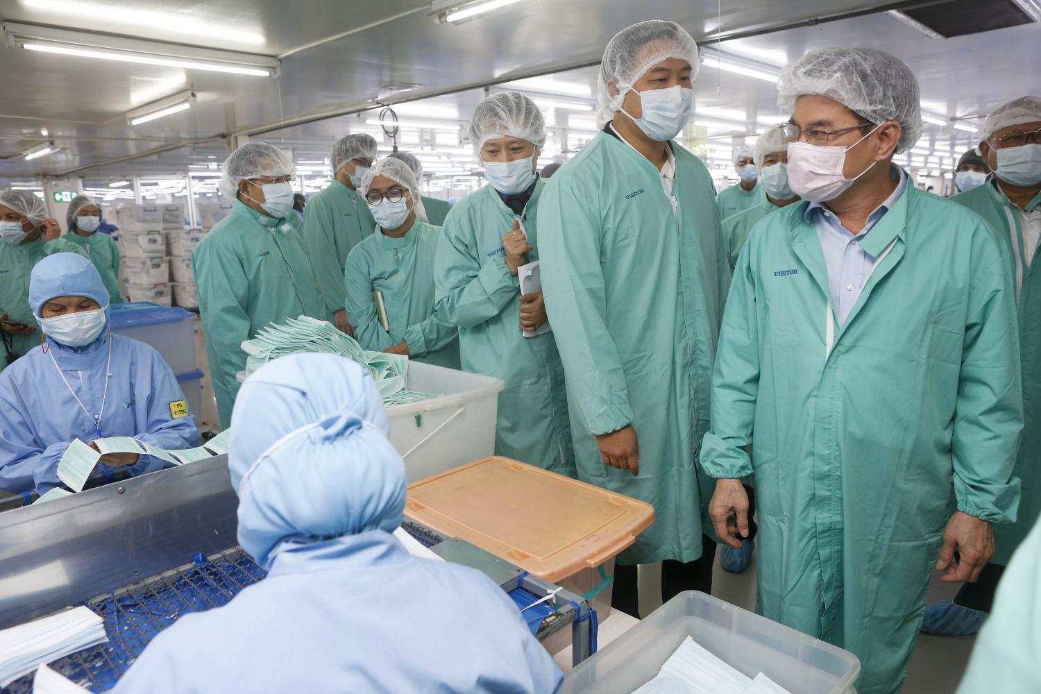 Commerce Minister Jurin Laksanavisit (right) visits a face mask factory in Nonthaburi's Pak Kret district. (Photo by Pattarapong Chatpattarasill)