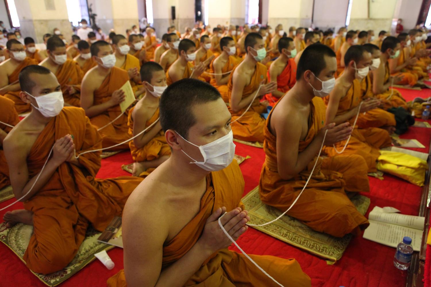 Monks from various temples on Sunday gather in the ubosot at Wat Maha That Yuwarat Rangsarit of Bangkok's Phra Nakhon district for evening prayer seeking blessings for the victims of the Covid-19 outbreak and an end to the rapid spread of the virus in all parts of the world. Arnun Chonmahatrakool