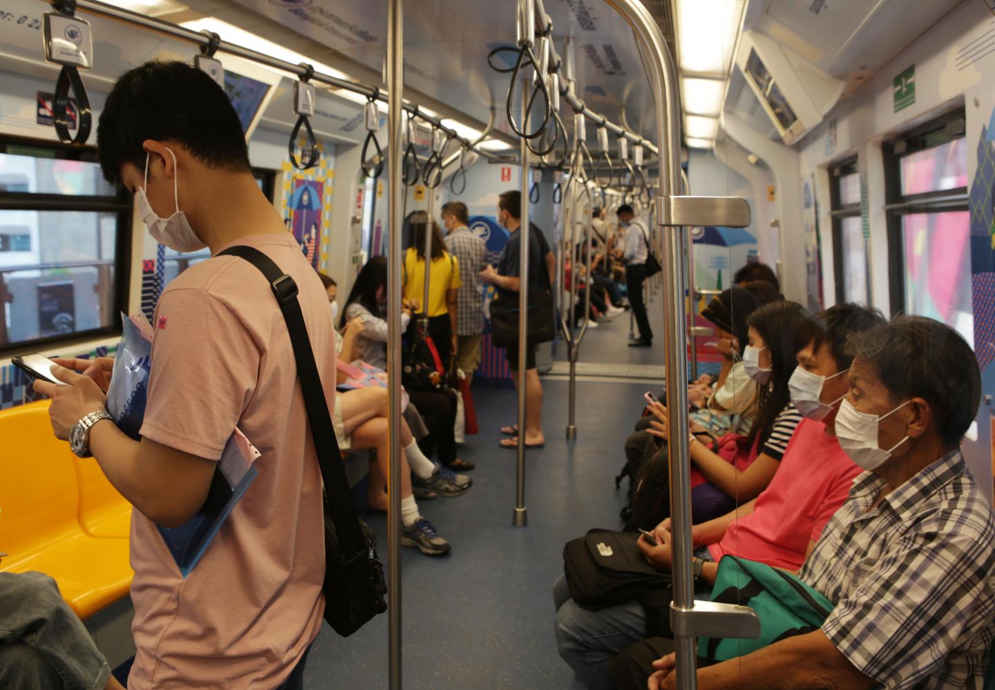 Some passengers on a BTS train wear face masks on Tuesday to protect themselves from Covid-19. From Wednesday onwards the Rail Department strictly requires all rail passengers to wear face masks and leave sufficient space between one another while travelling on a train or at a station. (Photo by Apichit Jinakul)