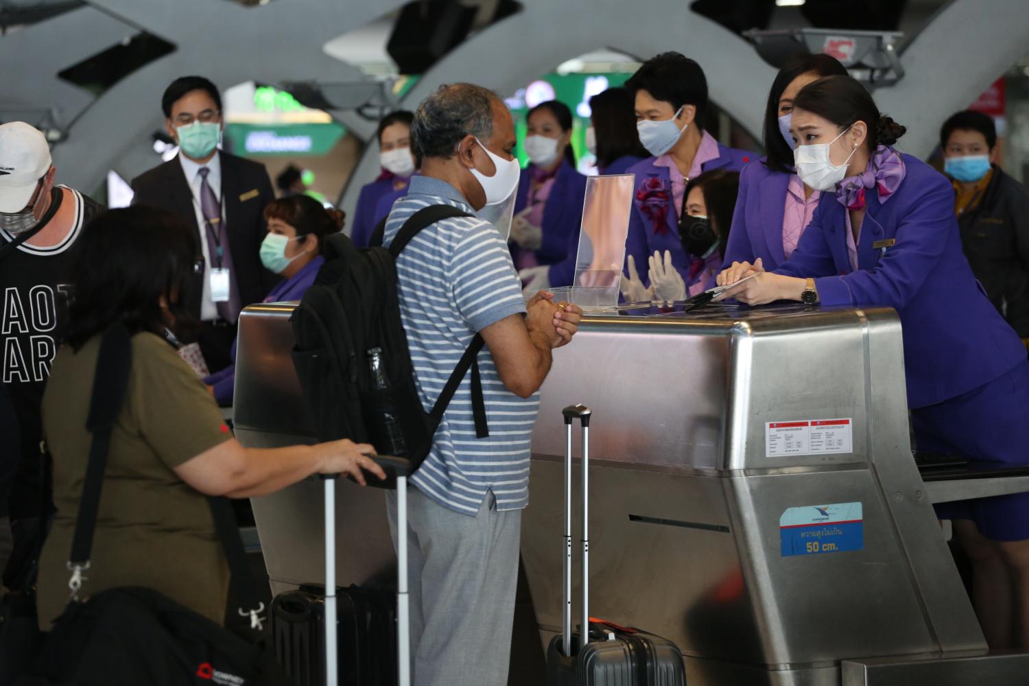 Passengers on Sunday check in at a THAI counter at Suvarnabhumi Airport to board a chartered flight from Bangkok to Auckland in New Zealand. (Bangkok Post photo)