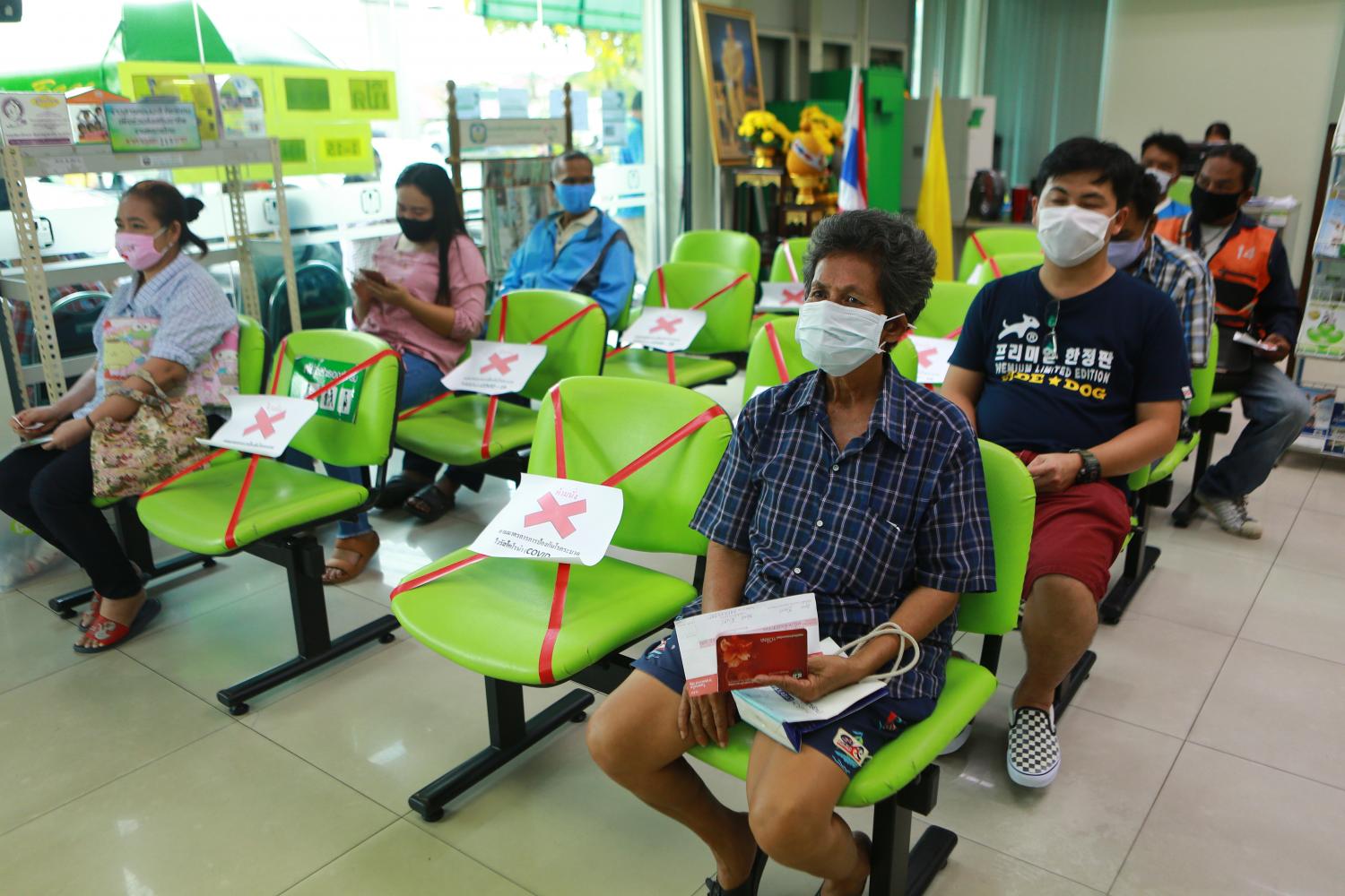 Farmers queue for aid at the BAAC's Samut Prakan branch. Somchai Poomlard