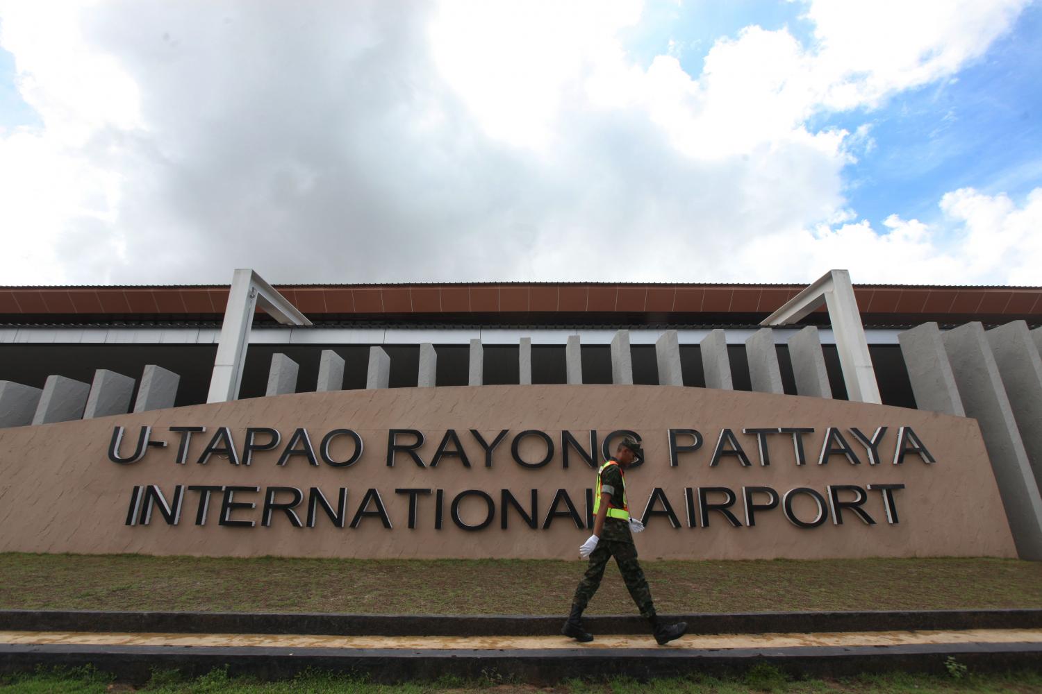 A man walks past a sign for U-tapao airport in Rayong. Investment in the EEC is expected to revive after a slowdown in March and April. (Photo by Thiti Wannamontha)