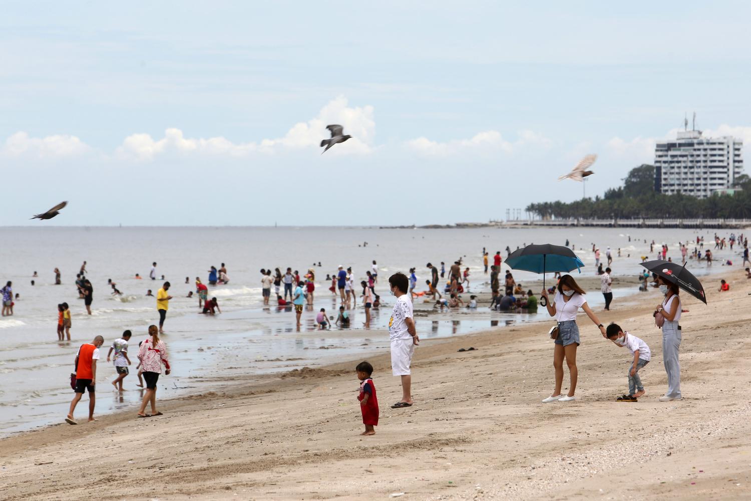 Visitors stroll along Bang Saen beach in Chon Buri province. The beach opened to the public on Monday after nearly two months of closure. (Photo by Wichan Charoenkiatpakul)