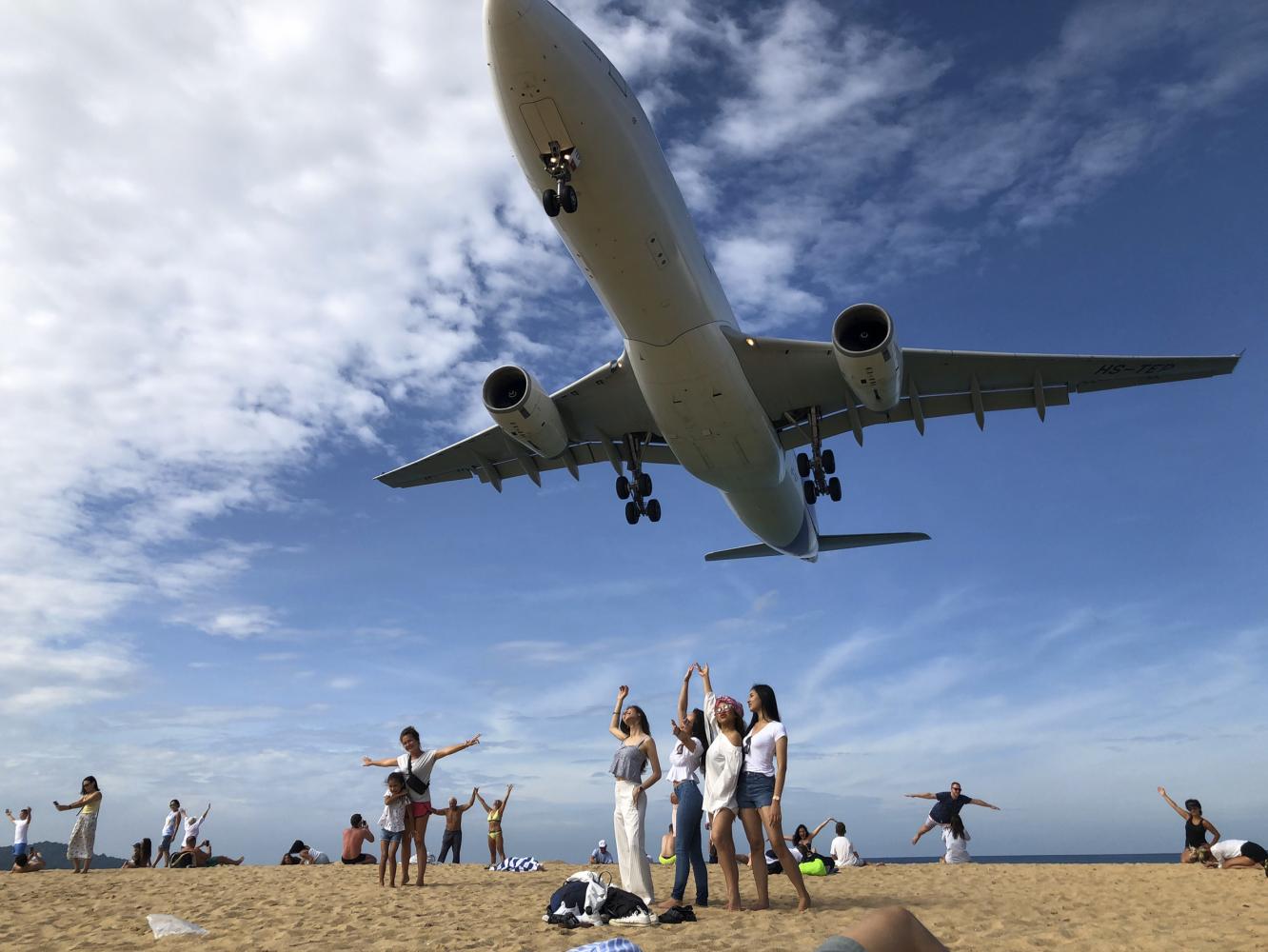Tourists pose for a picture at Mai Khao beach in Phuket. Domestic destinations have become popular among local tourists whose outbound travel plans were disrupted by the outbreak. Sarot Meksophawannakul