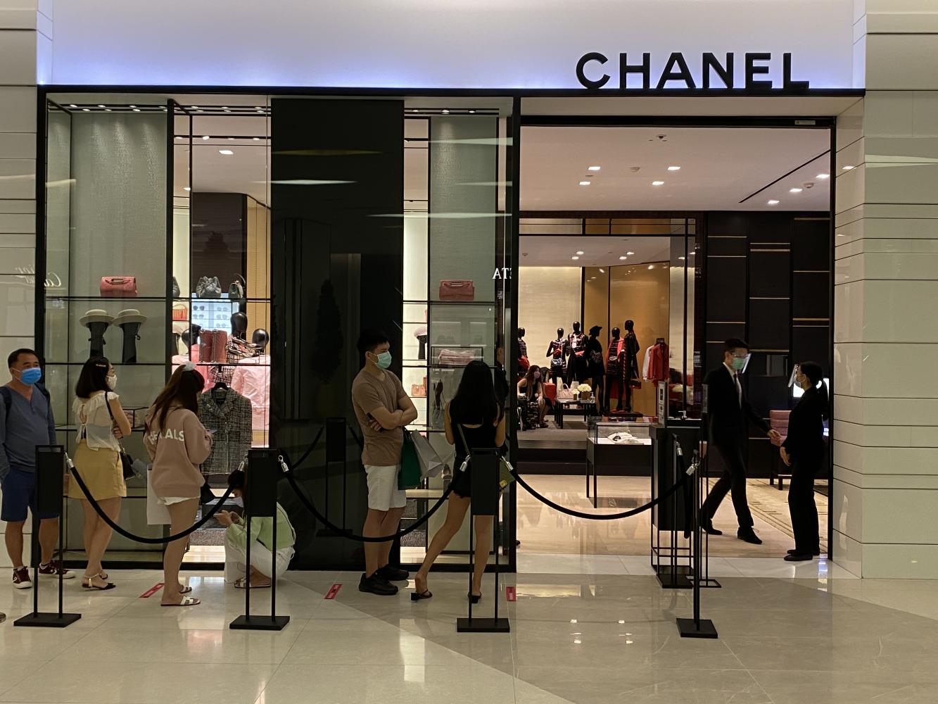 Customers wear face masks while waiting in a queue outside the Chanel store at Siam Paragon. Tourists from CLMV nations account for many of the foreign visitors at the mall. Bangkok Post Customers wear face masks while waiting in a queue outside the Chanel store at Siam Paragon. Tourists from CLMV nations account for many of the foreign visitors at the mall. Bangkok Post