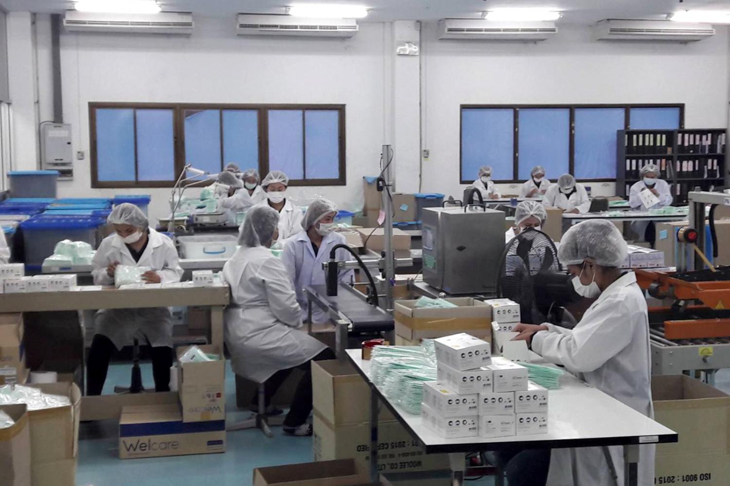 Workers make disposable face masks at a factory. According to the Internal Trade Department, Thailand has a surplus of 1.2 million face masks a day. (Photo by Jerdsak Saengthongcharoen)