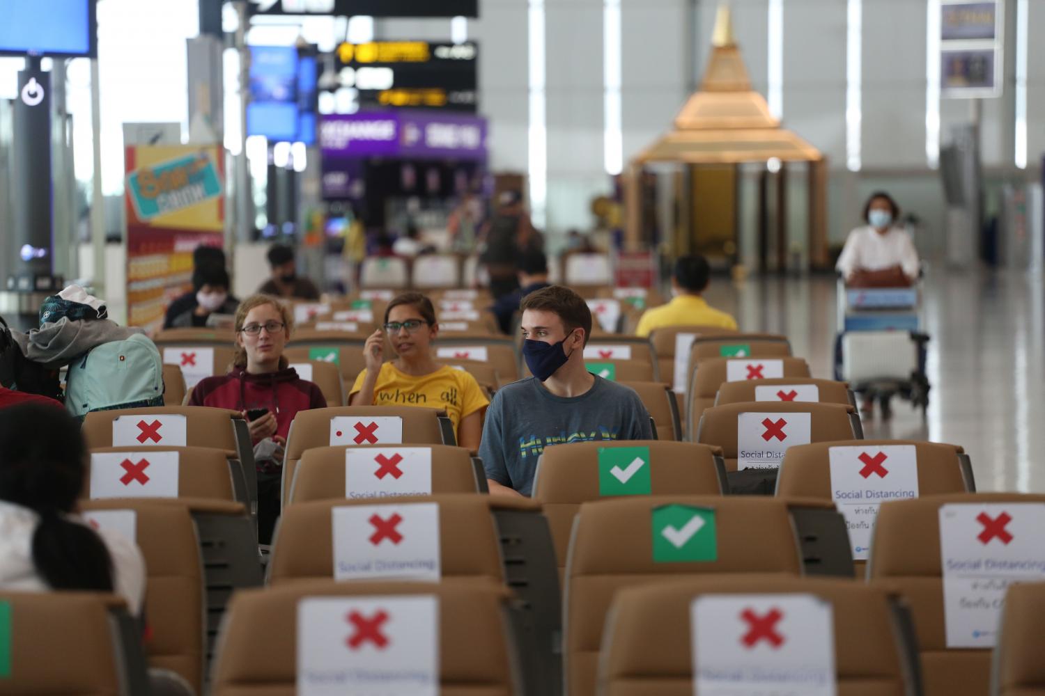 Tourists wear face masks and socially distance their seating at Suvarnabhumi airport. Varuth Hirunyatheb