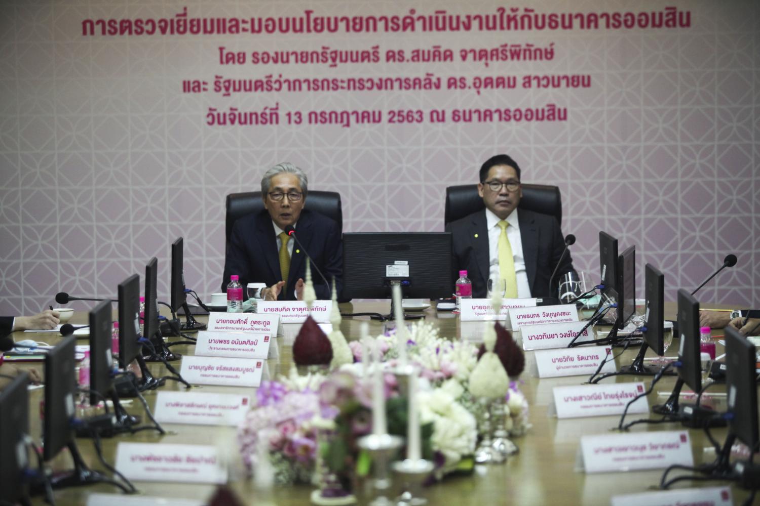 Deputy Prime Minister Somkid Jatusripitak is accompanied by Finance Minister Uttama Savayana (right) during the meeting held at the headquarters of the Government Savings Bank. (Photo by Arnun Chonmahatrakool)