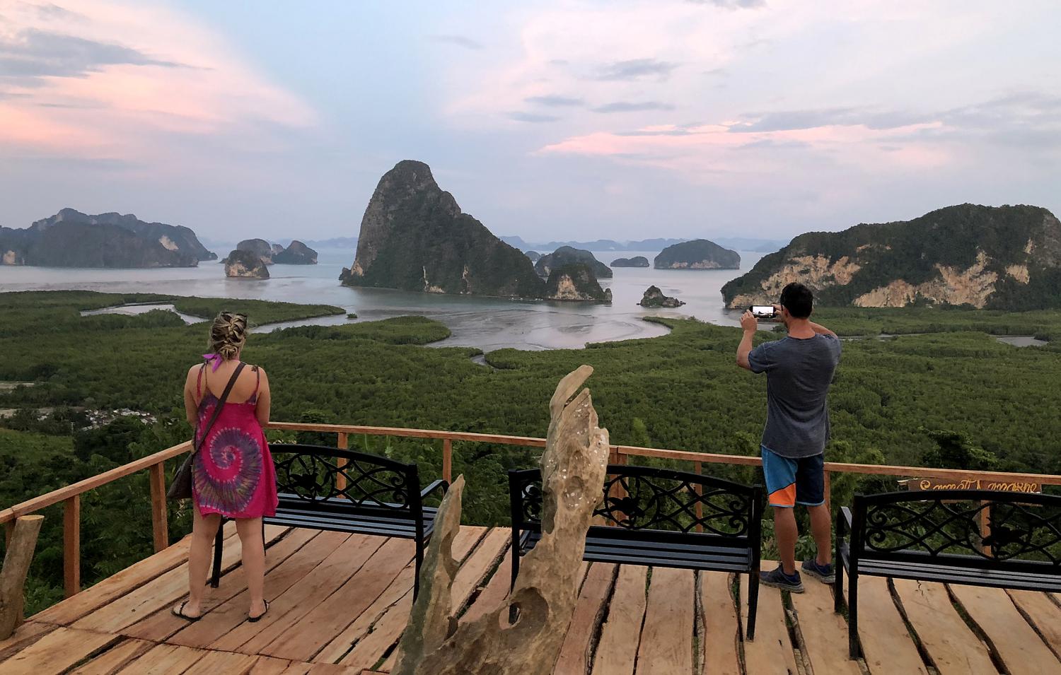 Foreign tourists take photos at the Samed Nang Chee viewpoint in Phangnga province. The Thai Hotels Association has asked the government to extend tourism stimulus benefits to expatriates in Thailand. (Photo by Sarot Meksophawan­nakul)