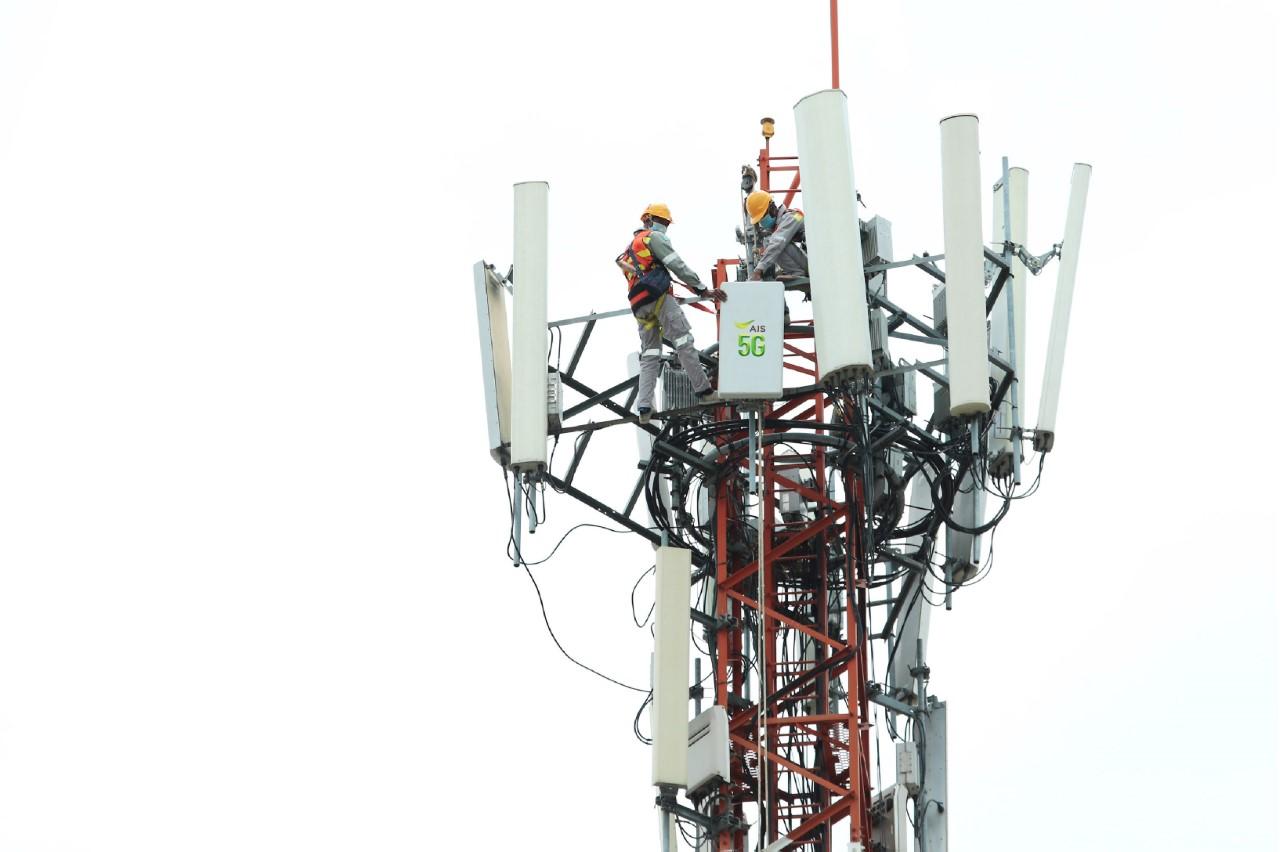 Workers perform maintenance atop an AIS 5G tower.