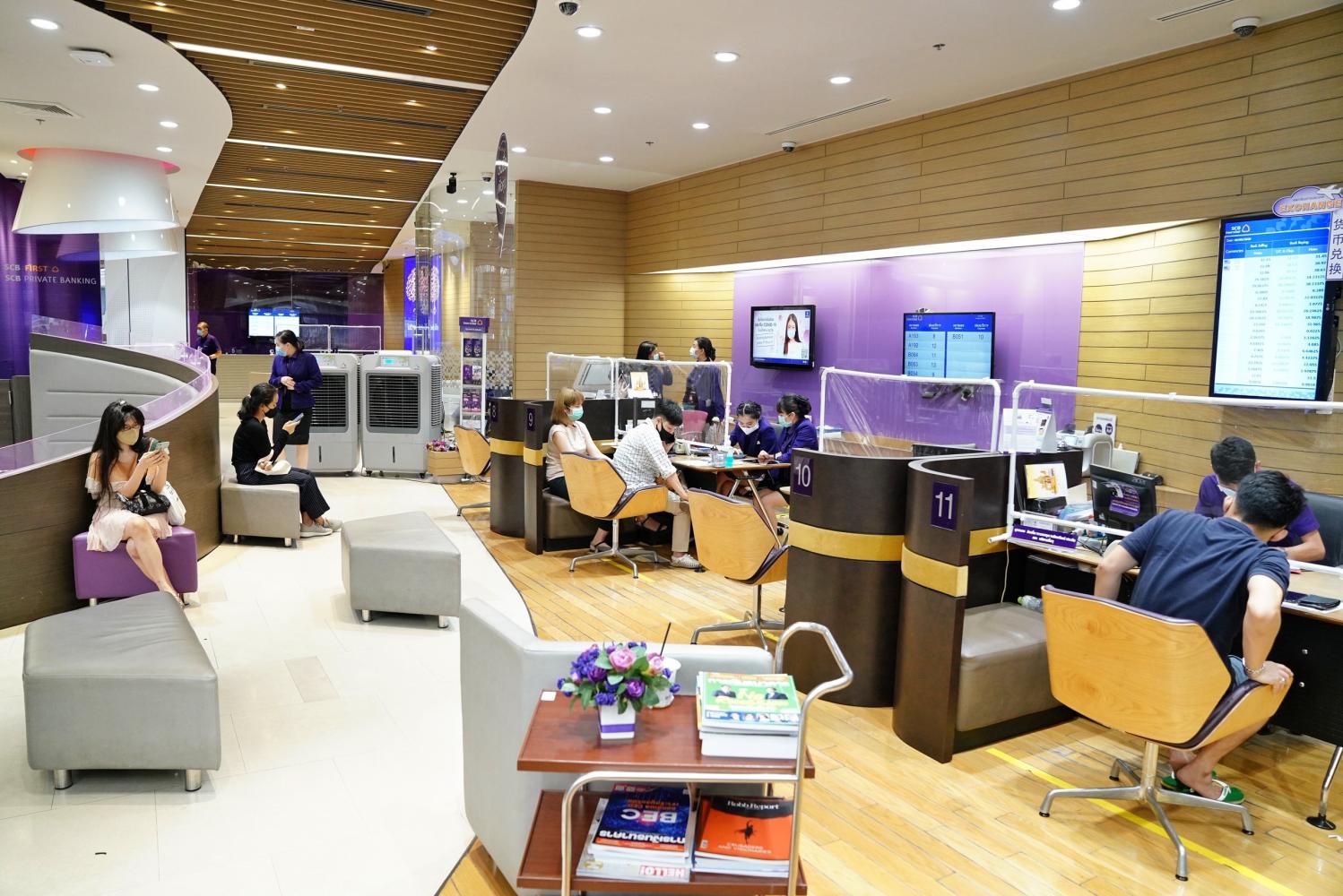 Customers wait to be served at a branch of Siam Commercial Bank in Bangkok.