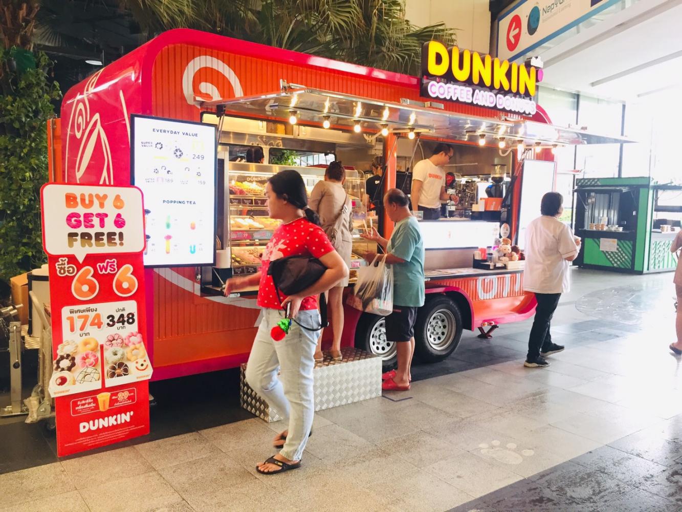 People browse offerings at a Dunkin' truck. The trucks operate in high-traffic areas.