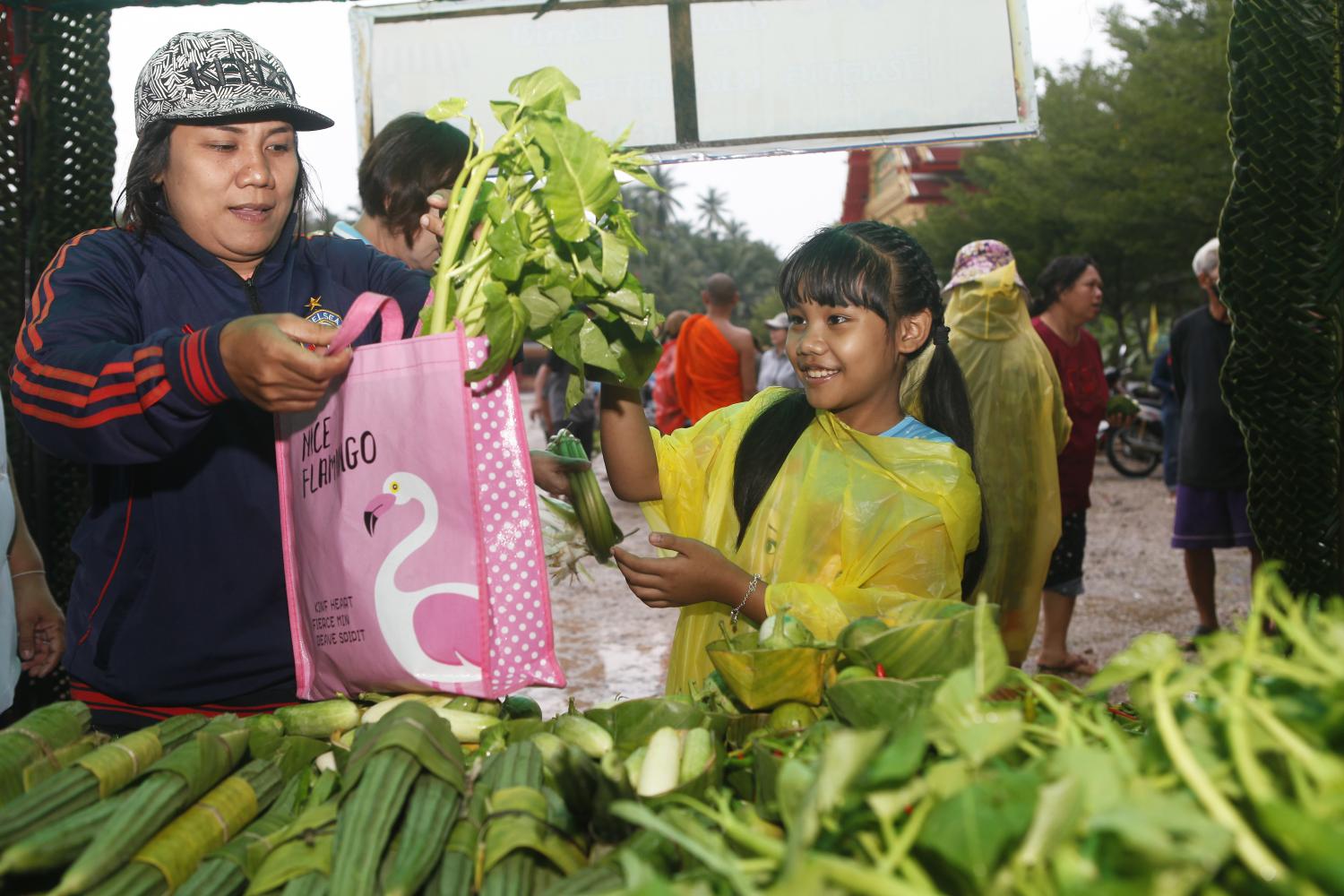 A friend where needed: A family picks vegetables given away for free at Wat Bang Khonthi Nai in Samut Songkhram province. The free produce project has forged a sense of sharing and enabled some families to put away money for a rainy day.