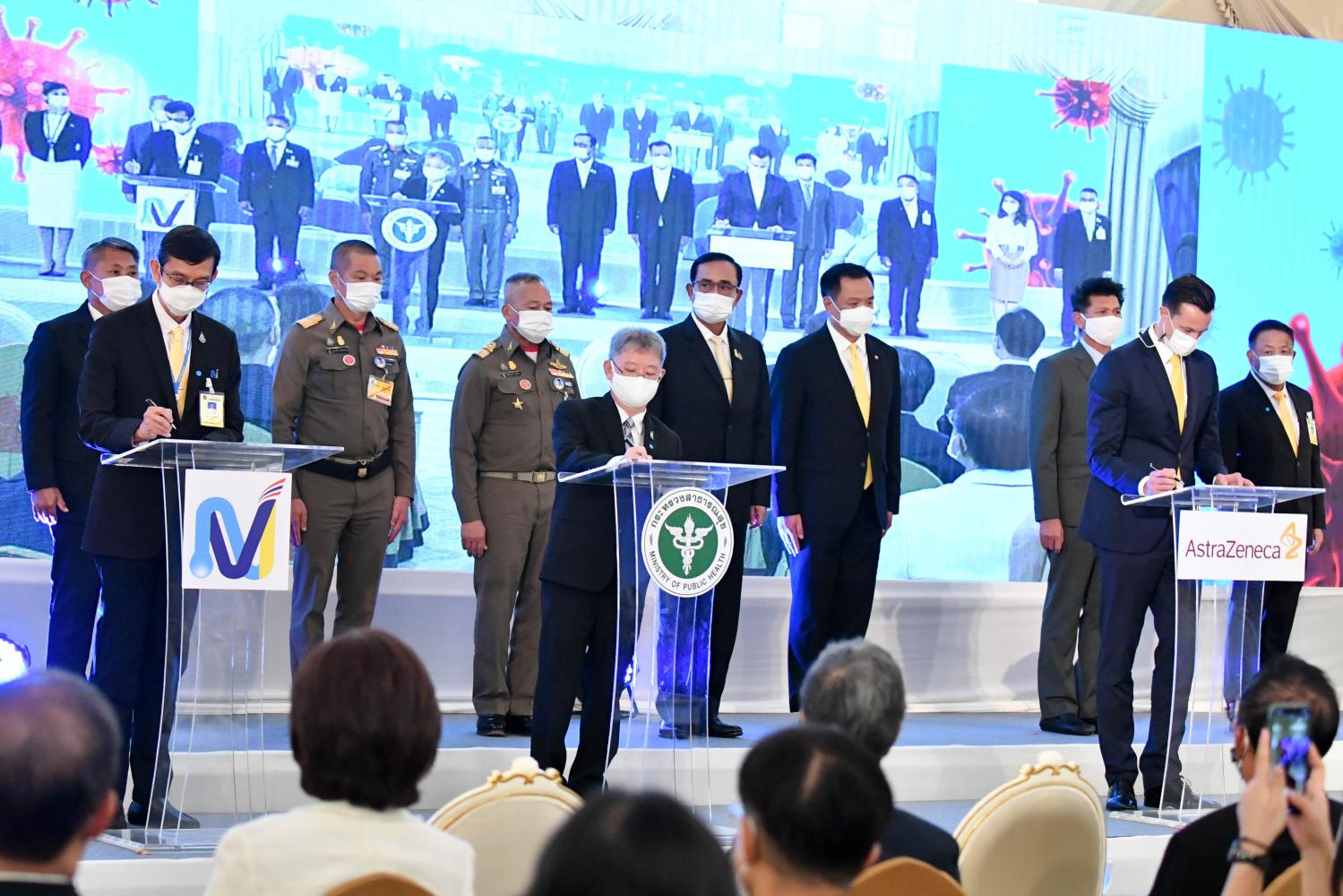 NVI director Nakorn Premsri, left, joins Disease Control Department director-general Opas Kankawinphong, centre, and AstraZeneca Thailand president James Teak at a signing ceremony at Government House on Friday. (Government House photo)