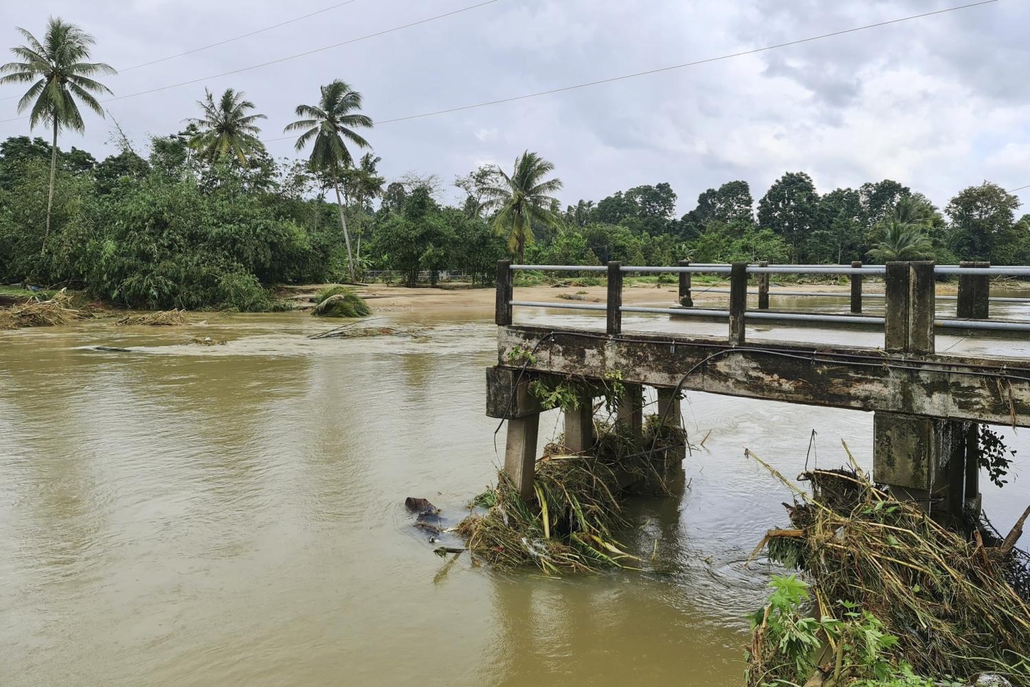 A bridge crossing the Tha Di canal in Lan Saka district, Nakhon Si Thammarat, has collapsed due to major flooding that has ravaged the province since Wednesday. (Photo courtesy of Nakhon Si Thammarat Facebook page)