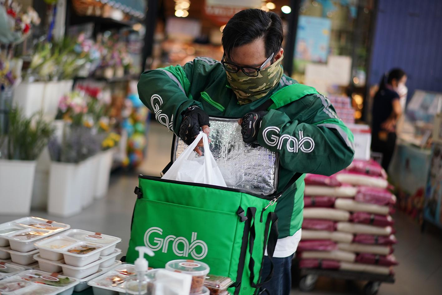 A Grab delivery driver picks up orders received online for delivery.