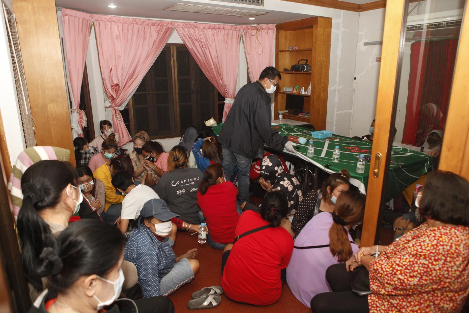 No stone unturned: A police officer inspects a table during a raid on a suspected gambling den in Nonthaburi province on Thursday.