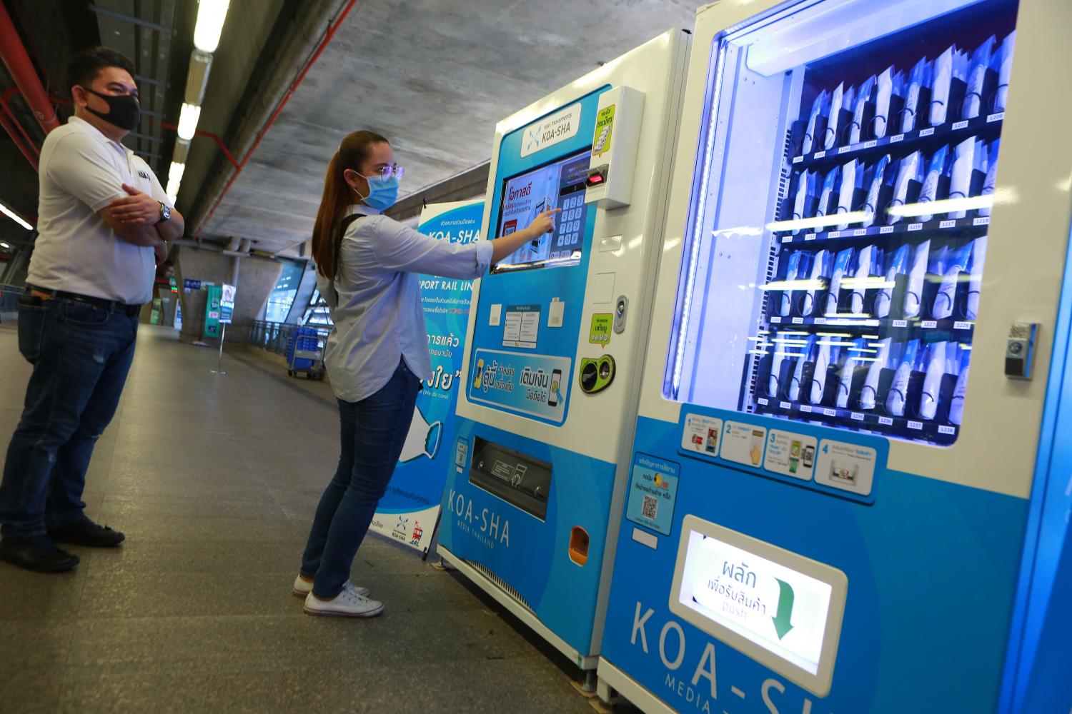 A woman purchases 25-baht fabric masks at the Makkasan Airport Rail Link station. (Photo by Somchai Poomlard)