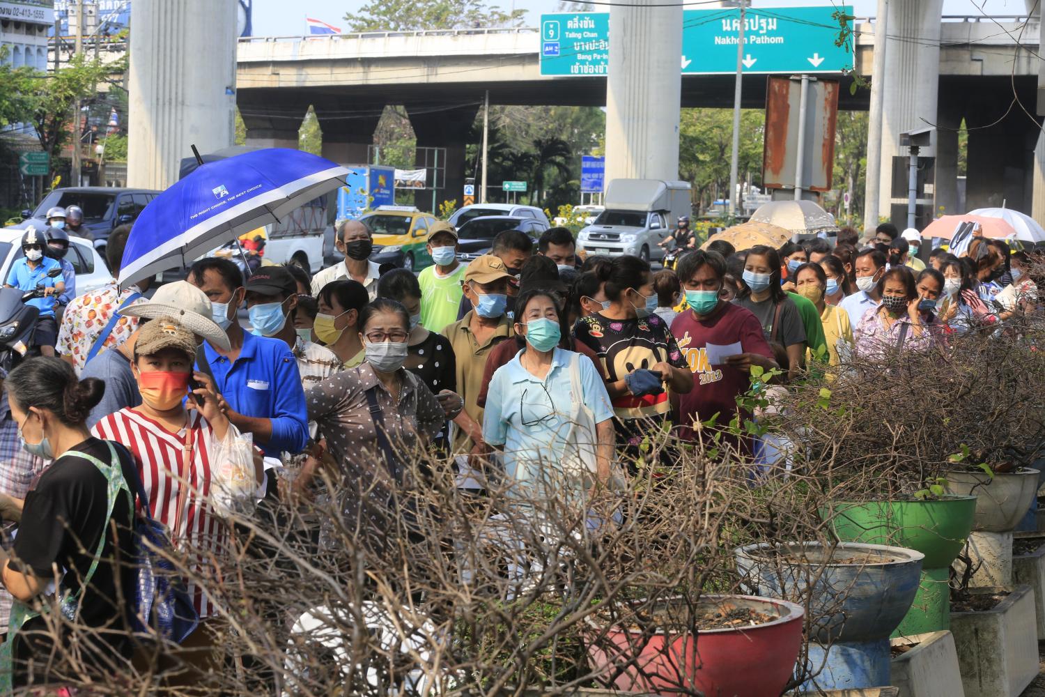 People queue up for Covid-19 testing at a park near the Mall Bang Khae in Bangkok's Bang Khae district. Four mobile testing vans, donated by the King, carried out proactive screening. Pornprom Satrabhaya People queue up for Covid-19 testing at a park near the Mall Bang Khae in Bangkok's Bang Khae district. Four mobile testing vans, donated by the King, carried out proactive screening. Pornprom Satrabhaya