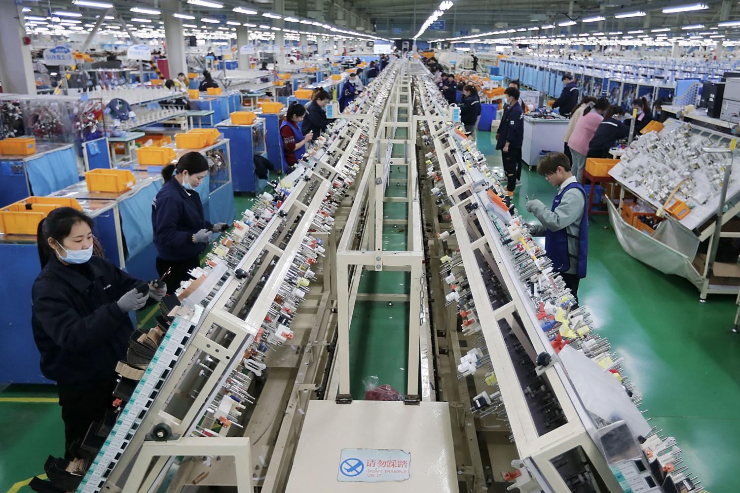 Workers on a wire harness production line at a factory in Huaibei, China in March. (Photo: STR/AFP) Workers on a wire harness production line at a factory in Huaibei, China in March. (Photo: STR/AFP)