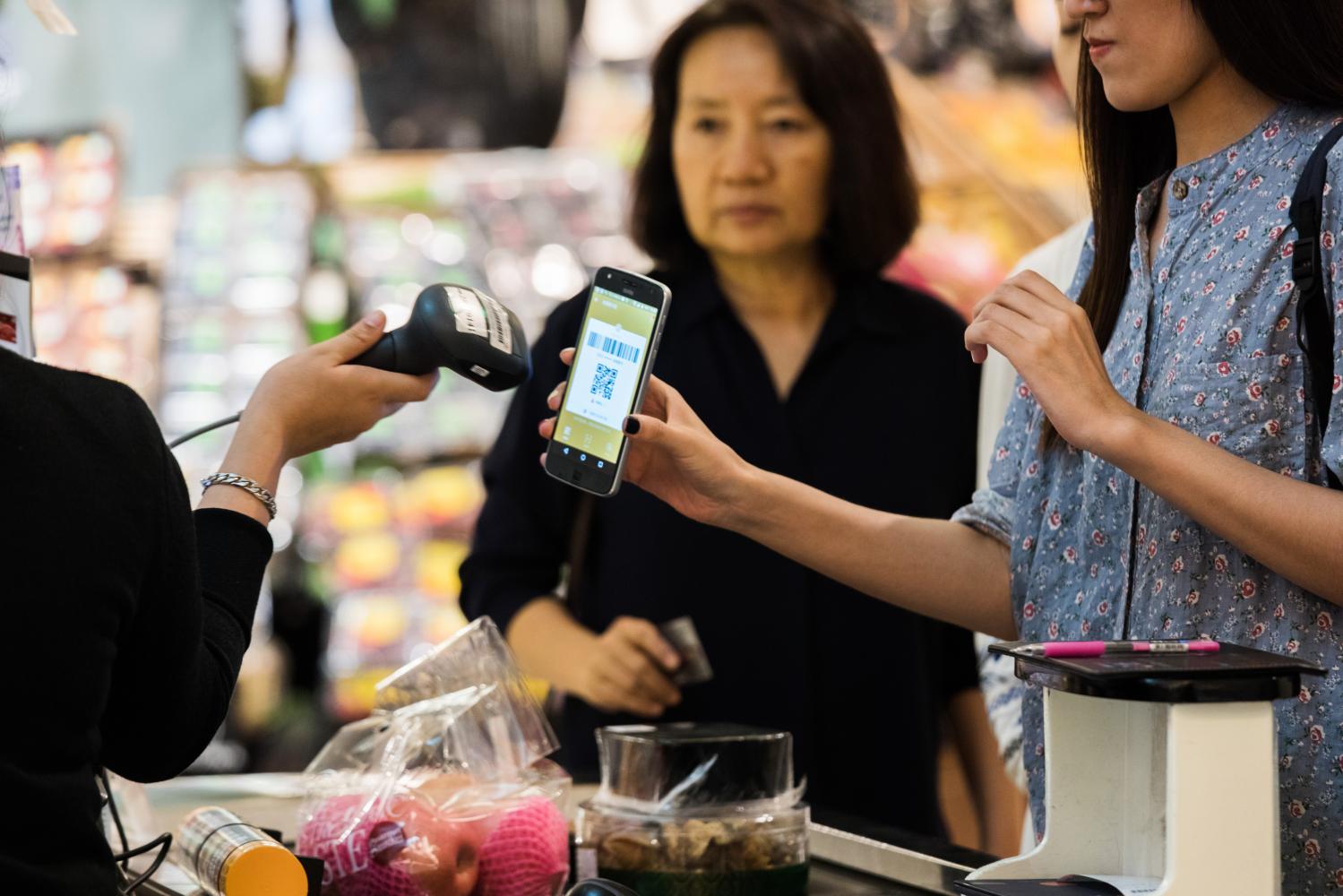 A customer has a QR code scanned from a smartphone at a grocery store in Bangkok.  (Photo: Bloomberg)