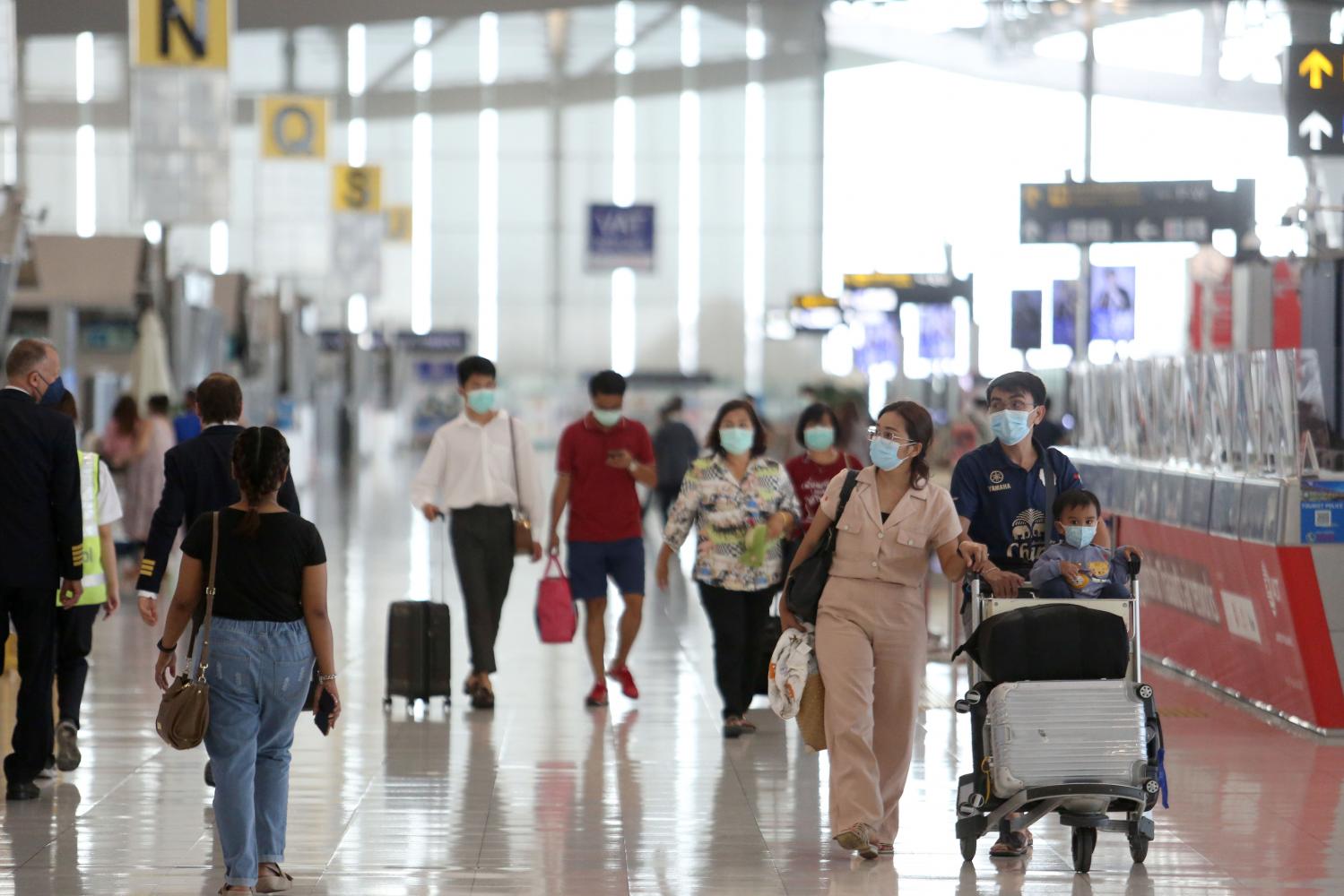 Travellers are seen wearing face masks at Suvarnabhumi airport amid the new surge in infections across the country. Wichan Charoenkiatpakul