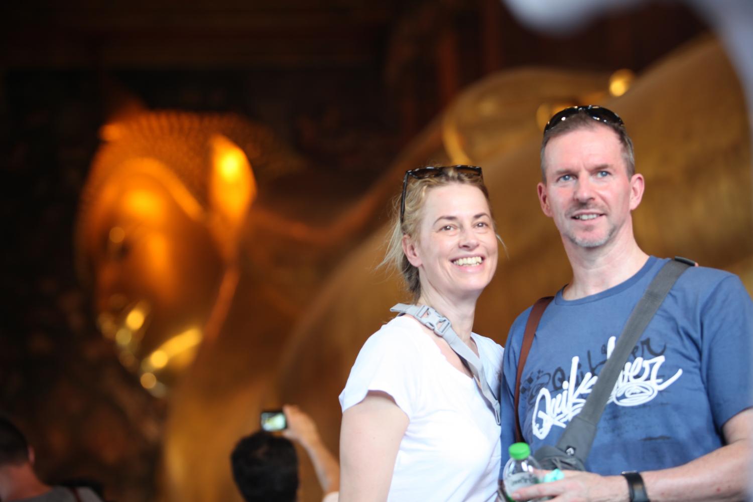 Foreign tourists pose for a photograph at Bangkok's Wat Pho, also known as the Temple of the Reclining Buddha or Wat Phra Chetuphon amid Covid-19. Apichart Jinakul