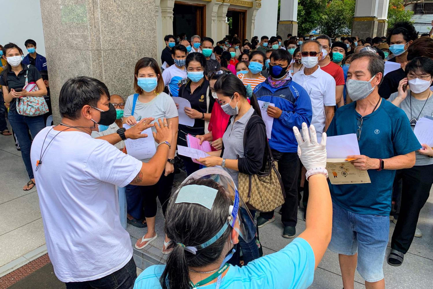 People wait to be inoculated with a Covid-19 vaccine at the Holy Redeemer Catholic church in Bangkok on Monday. AFP