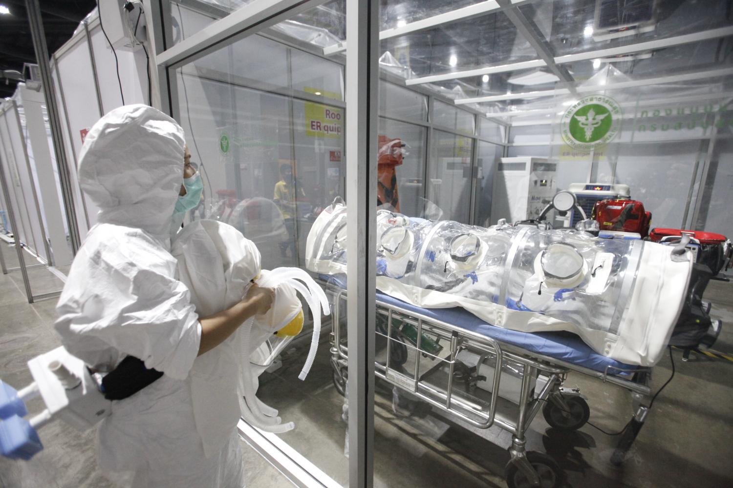 A medical worker in protective clothing looks into an emergency room for Covid-19 patients at Busarakam Hospital. (Photo: Pornprom Satrabhaya) A medical worker in protective clothing looks into an emergency room for Covid-19 patients at Busarakam Hospital. (Photo: Pornprom Satrabhaya)