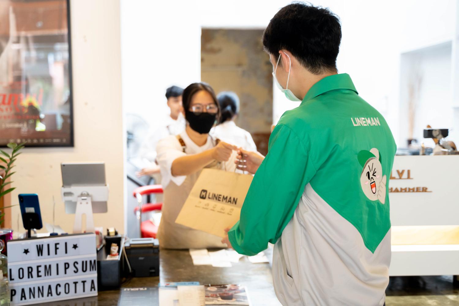 A delivery worker from Line Man Wongnai picks up an order amid the Covid-19 outbreak.