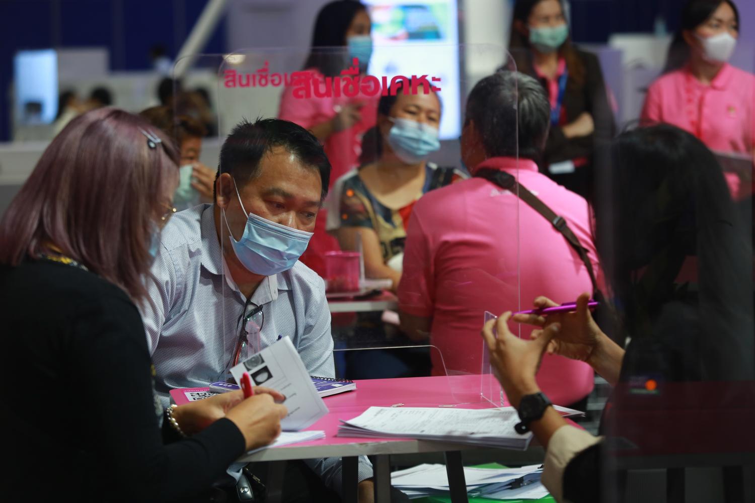 People discuss personal loans at a Money Expo held at Bitec in December. Household debt grew by around 5% in the first quarter this year. (Photo by Somchai Poomlard)