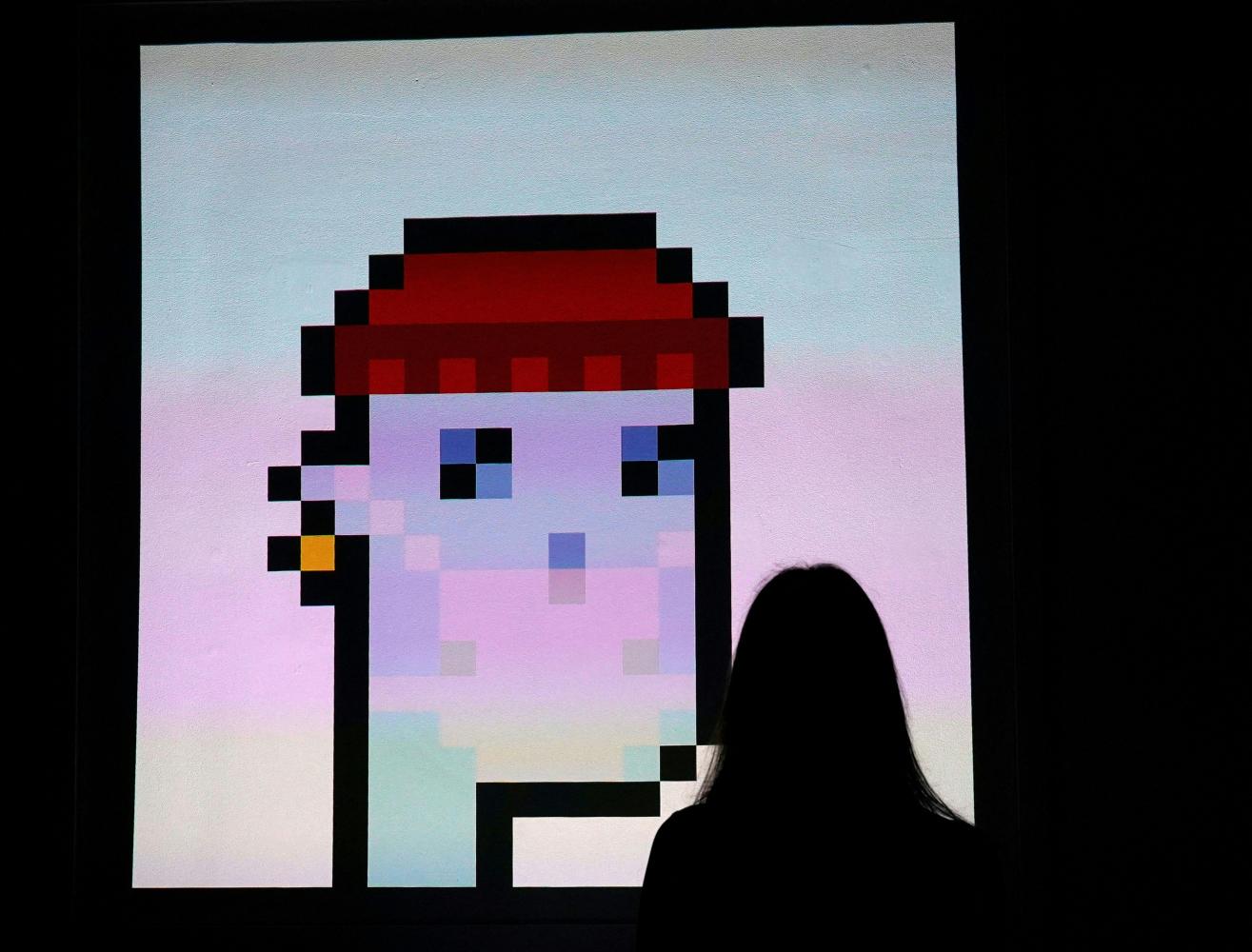 A woman looks at an NFT by Larva Labs titled "CryptoPunk 7523" during a media preview at Sotheby's in New York City. AFP