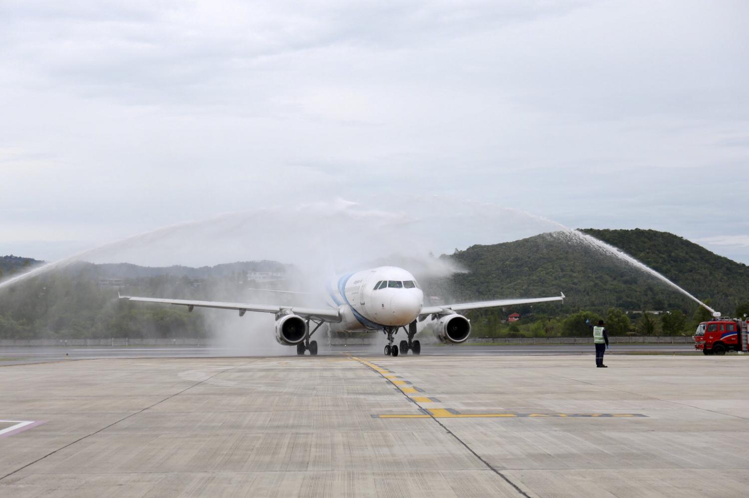 Fire engines spray water on a Bangkok Airways aircraft carrying the first group of foreign visitors to Koh Samui. (Photo: Supapong Chaolan)