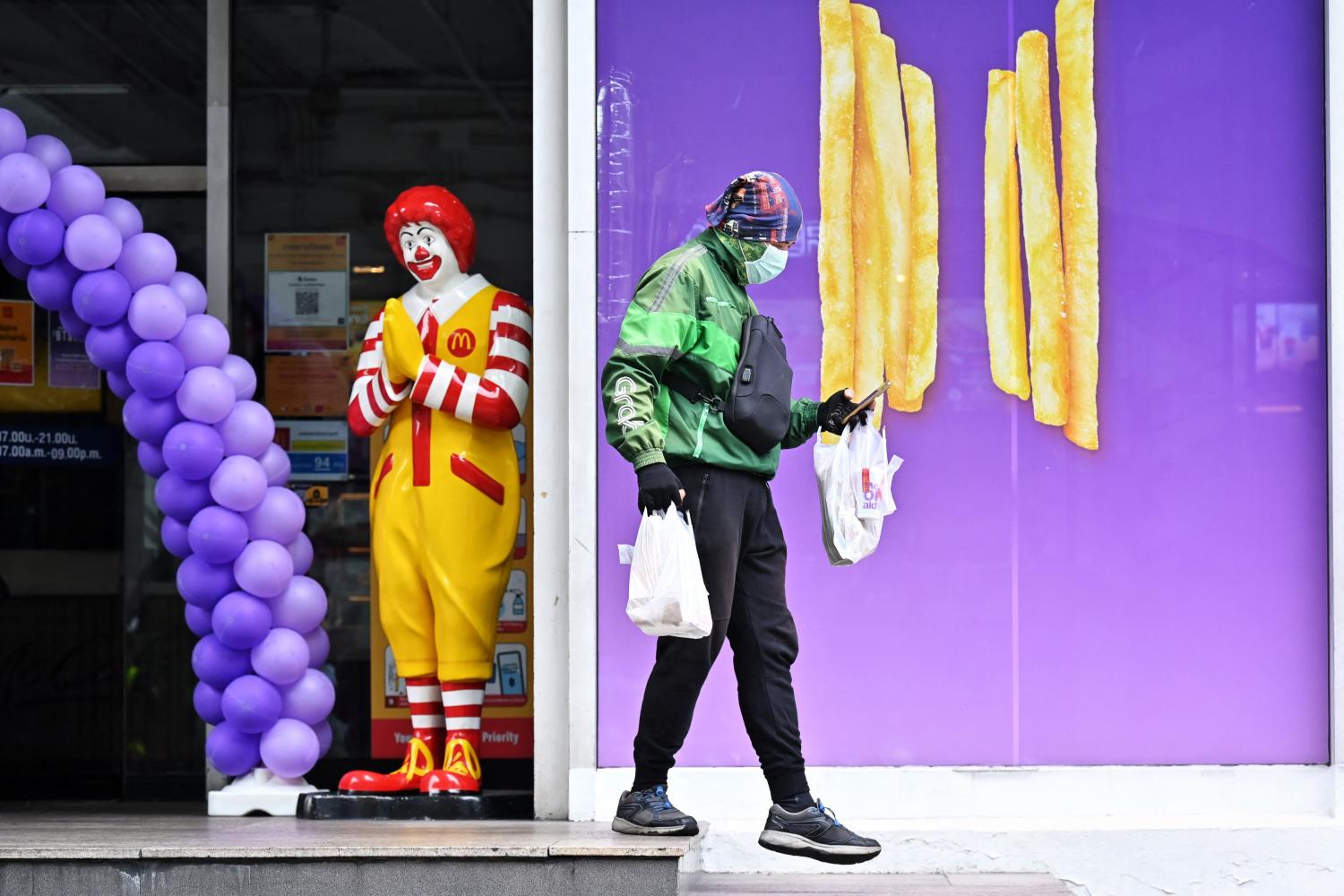 A GrabFood delivery driver picks up orders from a McDonald's branch in Bangkok on Friday, as dine-in bans continue due to Covid-19 restrictions across the country. AFP