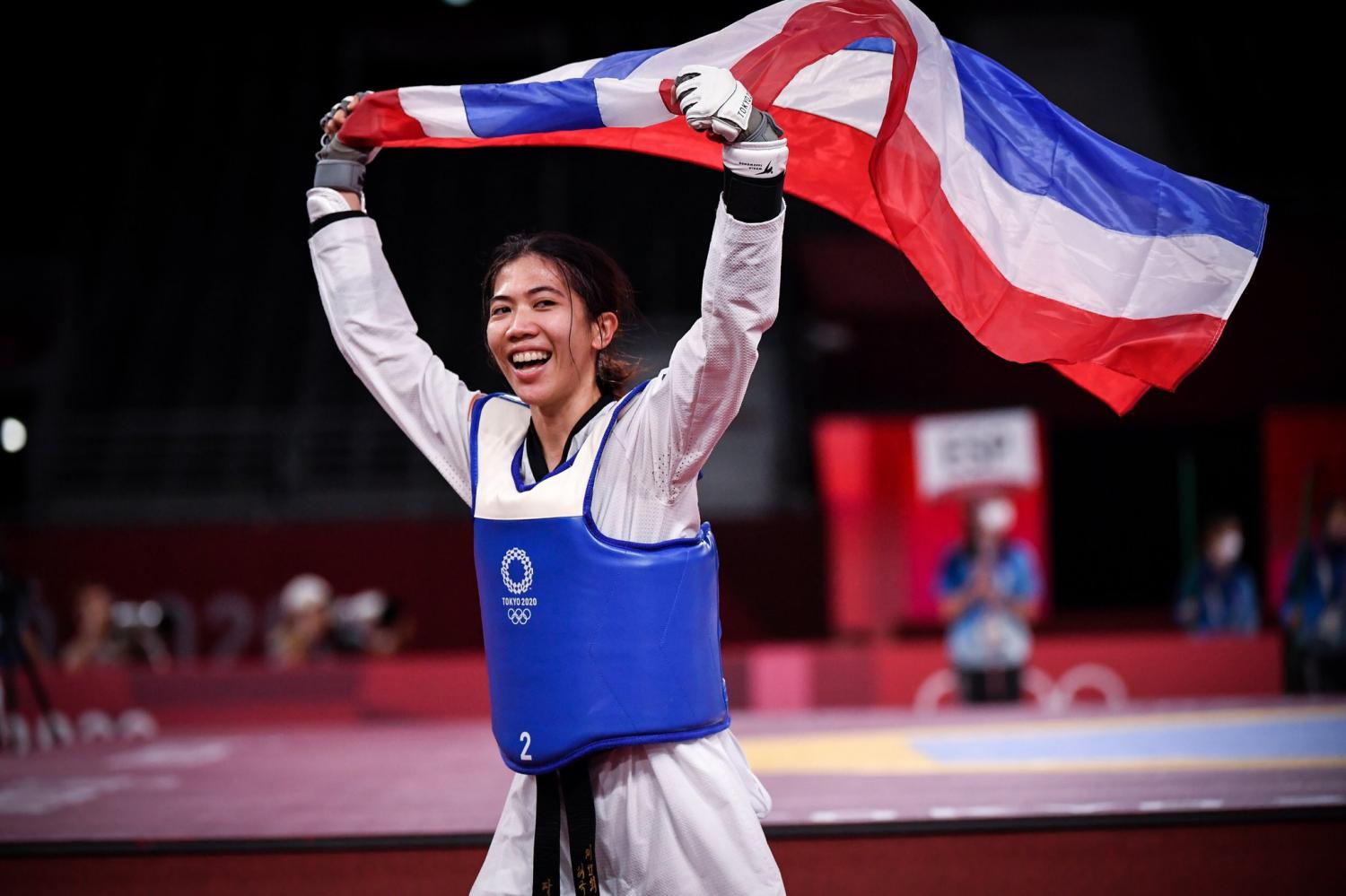 VICTORY RUN: Panipak Wongpattanakit celebrates with the Thai flag after winning the gold medal in the women's 49kg division at the Tokyo Olympics on Saturday.