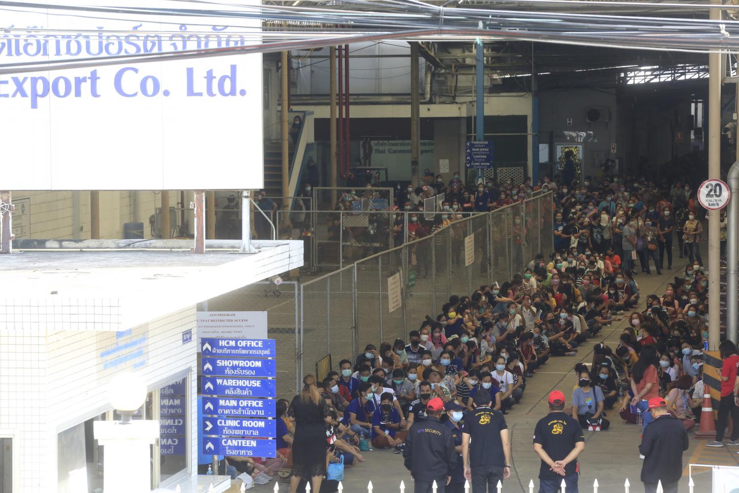 A large group of workers rally at a garment factory in Pak Kret district of Nonthaburi on June 29, 2021 after the management refused to suspend operations for cleaning following confirmation that at least 72 workers there had contracted Covid-19. (Photo: Pornprom Satrabhaya)