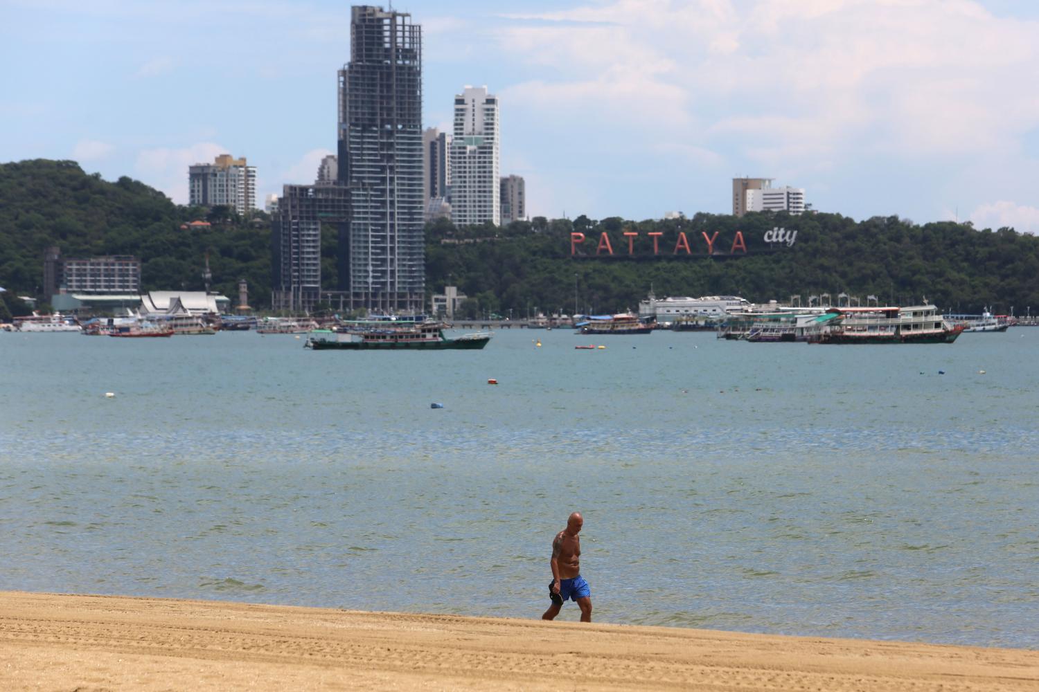 A lone man walks on the beach in Pattaya. (Photo: Wichan Charoenkiatpakul)