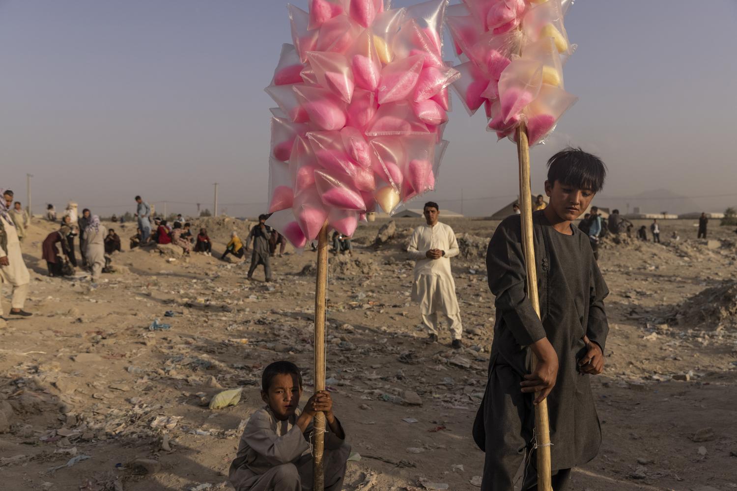 Boys sell cotton candy as people hoping to flee Afghanistan gather in a field outside Hamid Karzai International Airport in Kabul, on Monday. (Photo courtesy of VICTOR J. BLUE)