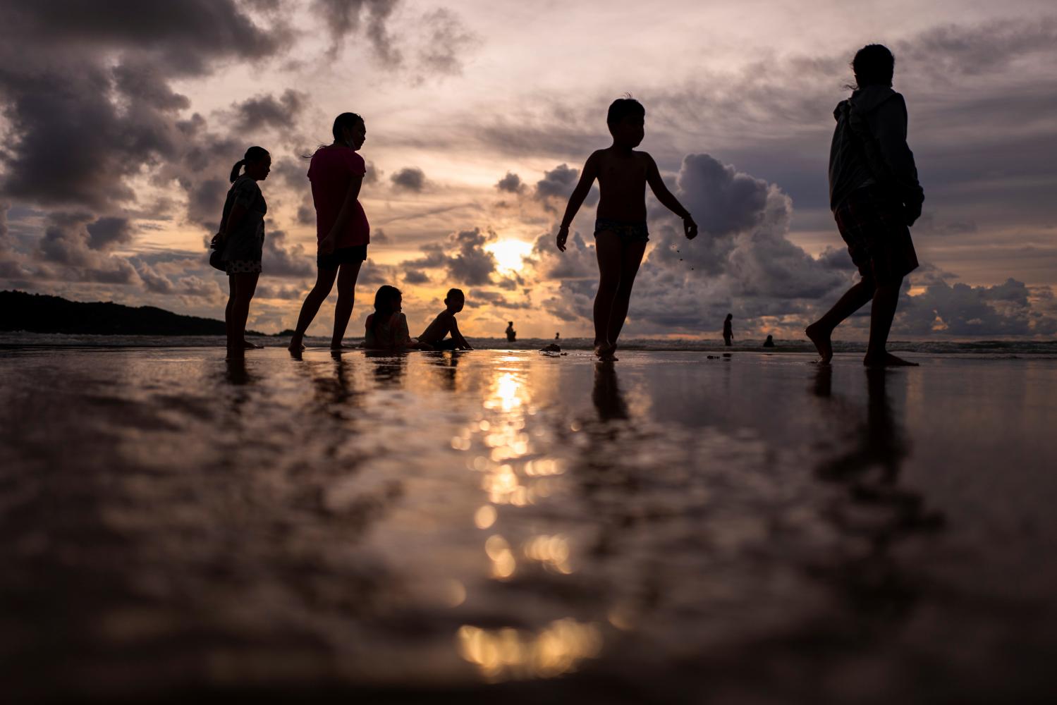 People enjoy at a beach in Phuket on Sunday. The island has opened for foreigners who are fully vaccinated to visit the resort island without quarantine. (Reuters photo)