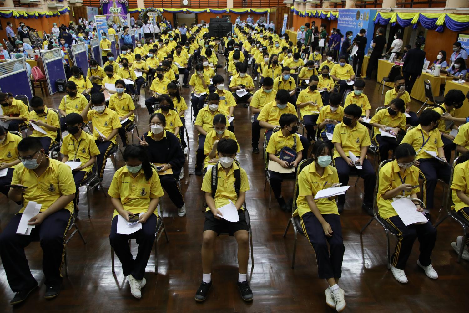 Students aged between 12-17 years at Surasak Montri school in Din Daeng district on Wednesday sit in a queue as they wait to get a Pfizer Covid-19 vaccination. (Photo: Arnun Chonmahatrakool) Students aged between 12-17 years at Surasak Montri school in Din Daeng district on Wednesday sit in a queue as they wait to get a Pfizer Covid-19 vaccination. (Photo: Arnun Chonmahatrakool)