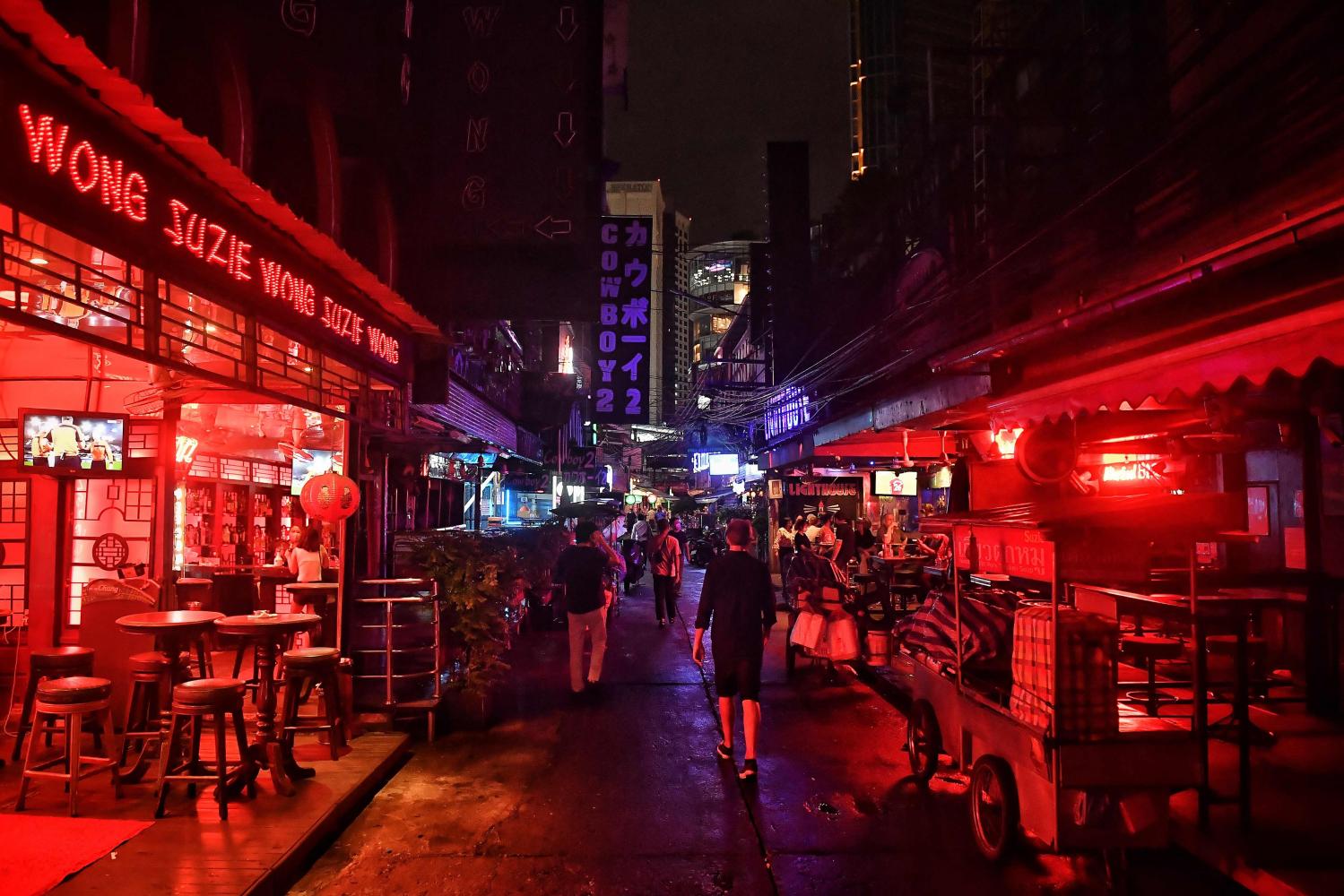 Les gens marchent le long de Soi Cowboy après que le gouvernement a commencé à assouplir les restrictions imposées aux activités sociales pour éloigner le coronavirus Covid-19.  La Thaïlande prévoit de rouvrir complètement les touristes vaccinés voyageant par avion en provenance de pays à faible risque à partir du 1er novembre. AFP