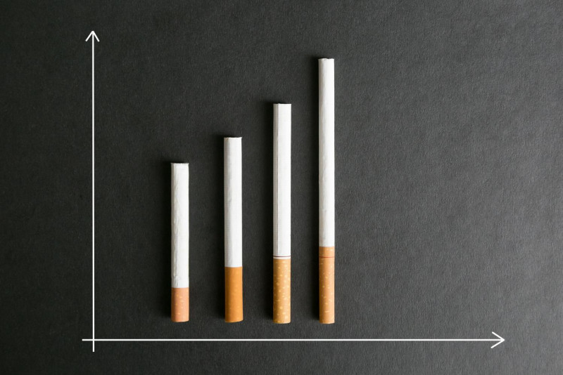 single cigarette Single cigarette isolated on red background, selective focus Stock Photo