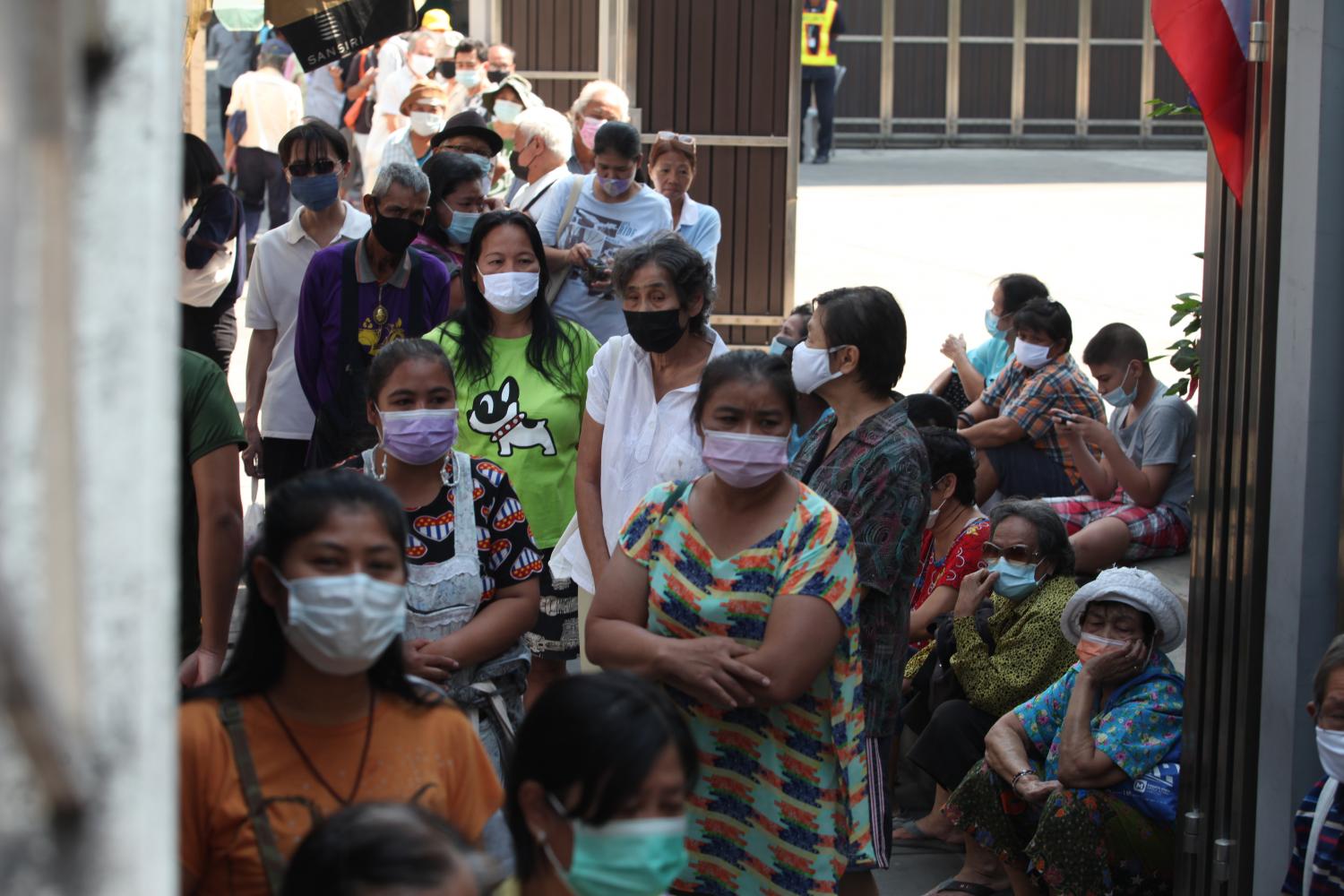 State welfare cardholders are pictured in a queue as they wait to make purchases under the 'We Win' scheme in February this year outside Siam Rattana supermarket in the capital's Wong Wien Yai area. (Photo: Apichart Jinakul)