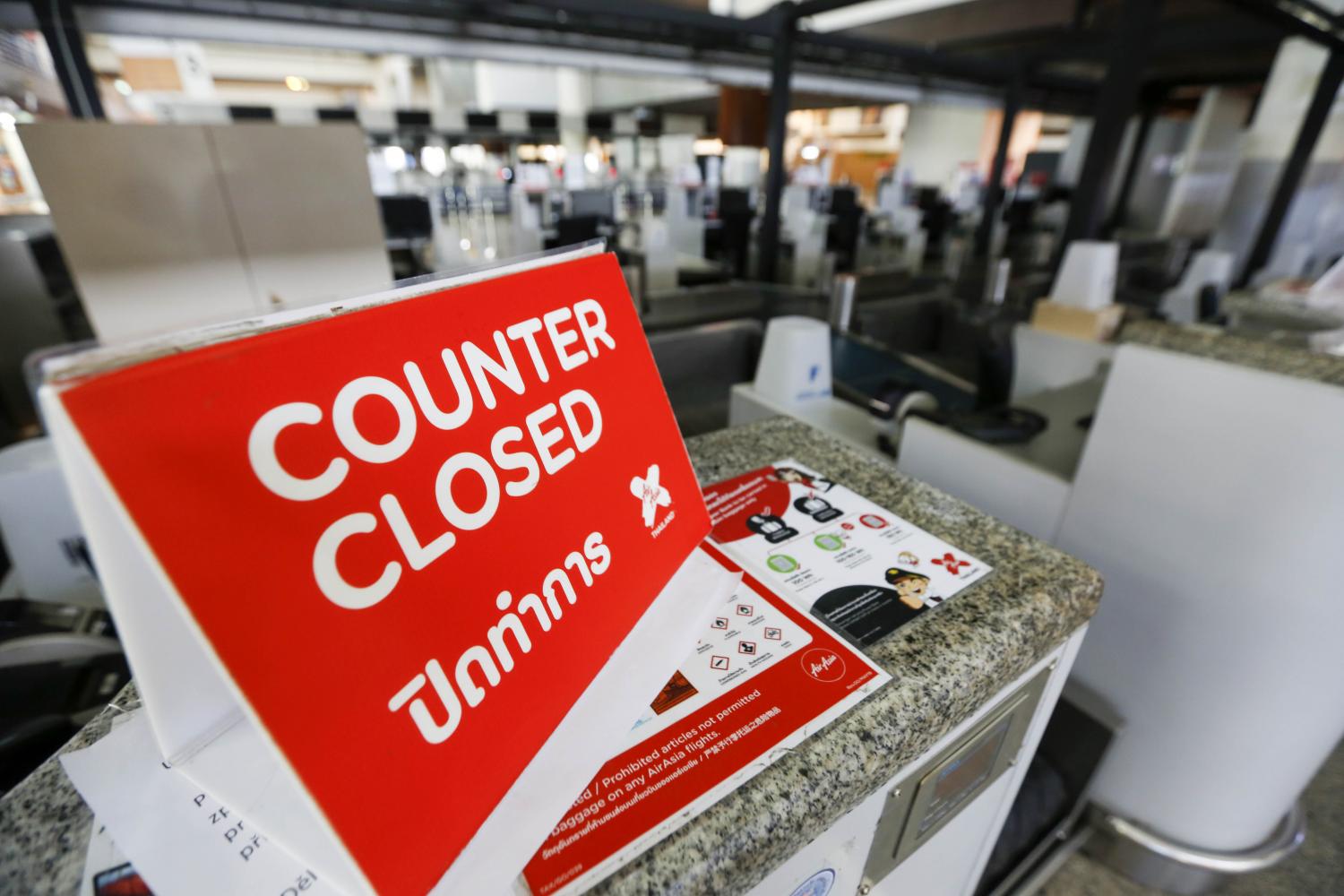 A sign is displayed on a Thai AirAsia check-in counter at Don Mueang airport during the lockdown. (Photo: Pattarapong Chatpattarasill)