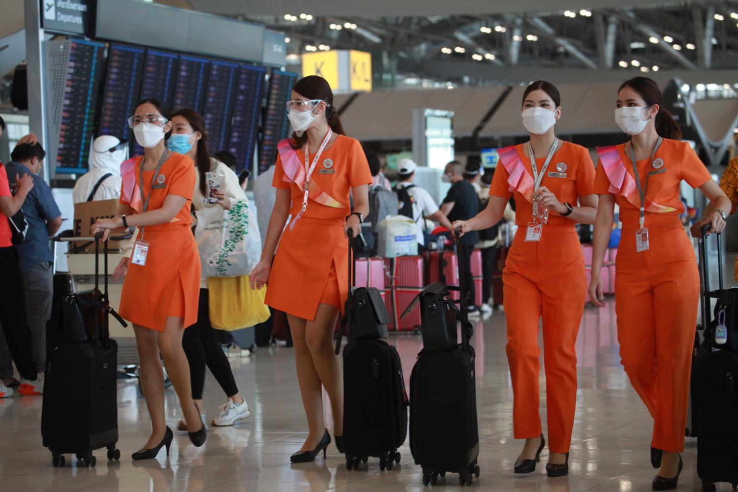 The cabin crew of regional airline Thai Smile wear face masks while walking through Suvarnabhumi airport. The cabin crew of regional airline Thai Smile wear face masks while walking through Suvarnabhumi airport.
