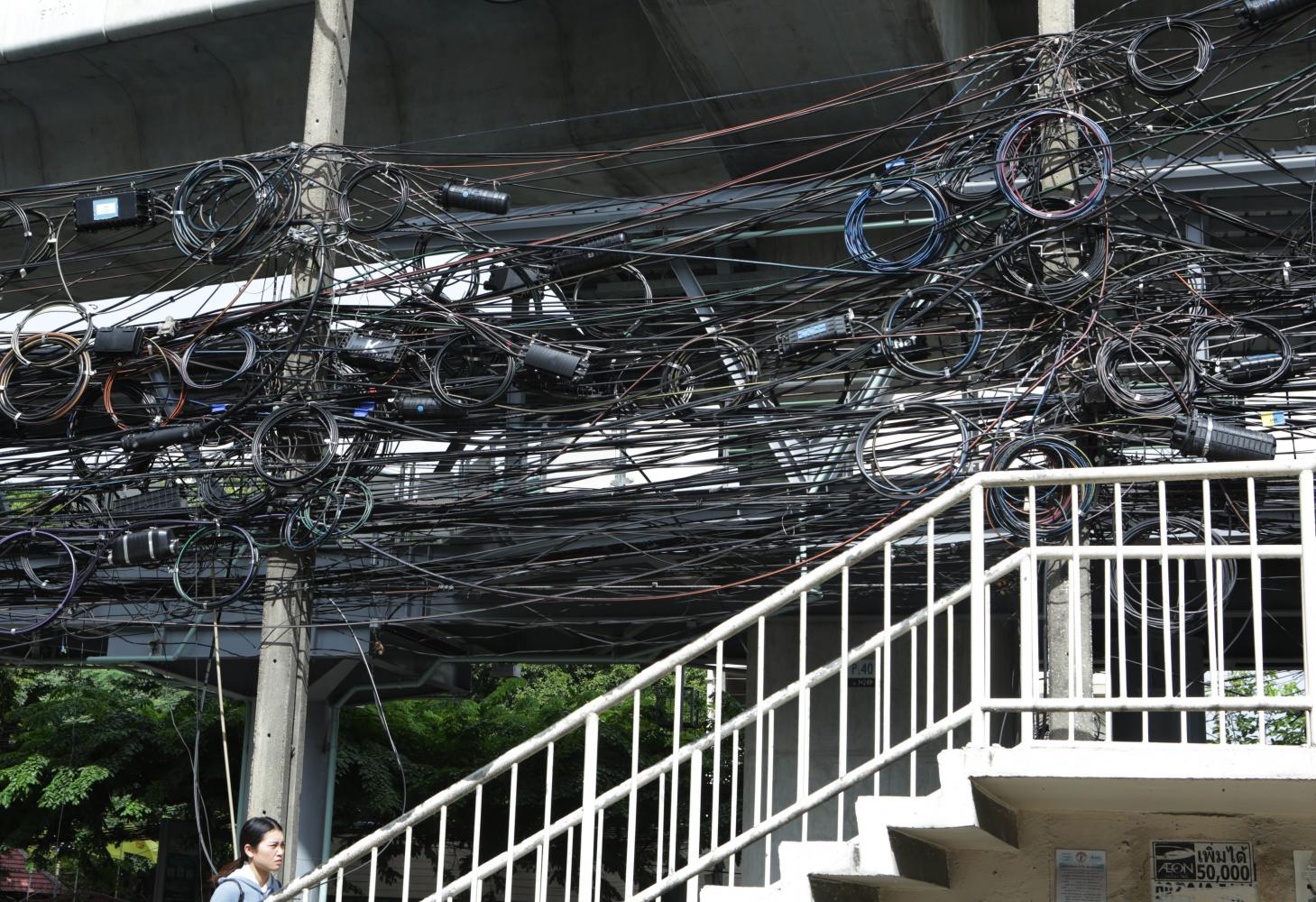 A rat's nest of cable wires hang above an overpass on Phahon Yothin Road in Bangkok. (Photo: Apichit Jinakul)