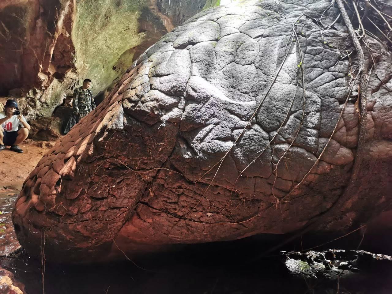 Tourists examine Naga Cave, which features rock formations that resemble giant snake scales.