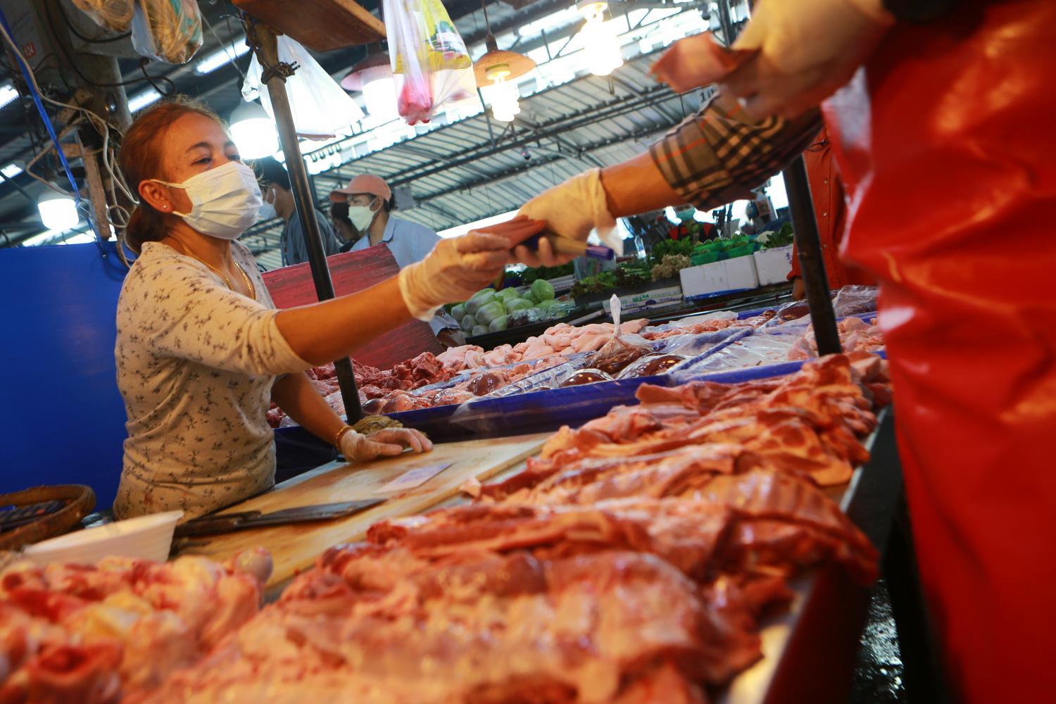 A vendor prepares pork meat for sale at a fresh market in Samut Prakan. Somchai Poomlard