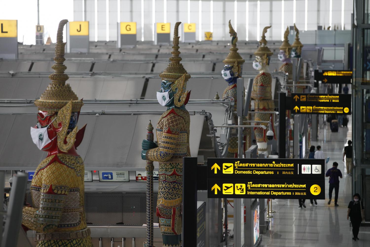 Yaksa statues at Suvarnabhumi airport are adorned with face masks to remind the public to remain vigilant during the Covid-19 pandemic. (Photo: Varuth Hirunyatheb)