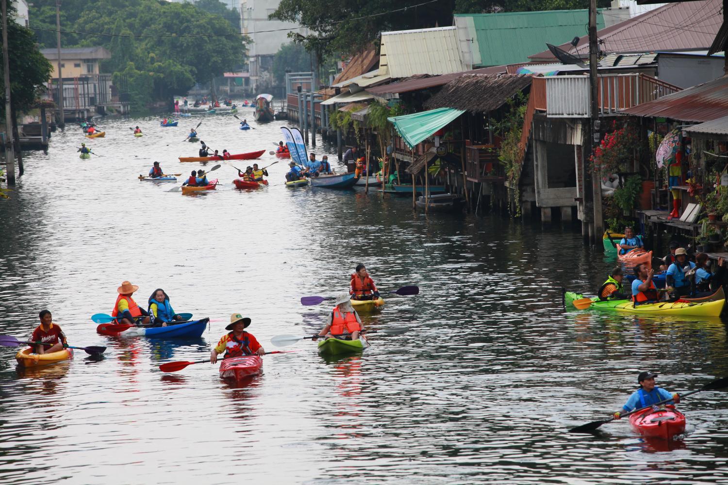 People paddle kayaks along a 10.34-km route near the Chao Phraya River on Sunday as part of an activity organised by the Bangkok Yai district office and community groups to promote eco-tourism. (Photo: Apichart Jinakul)